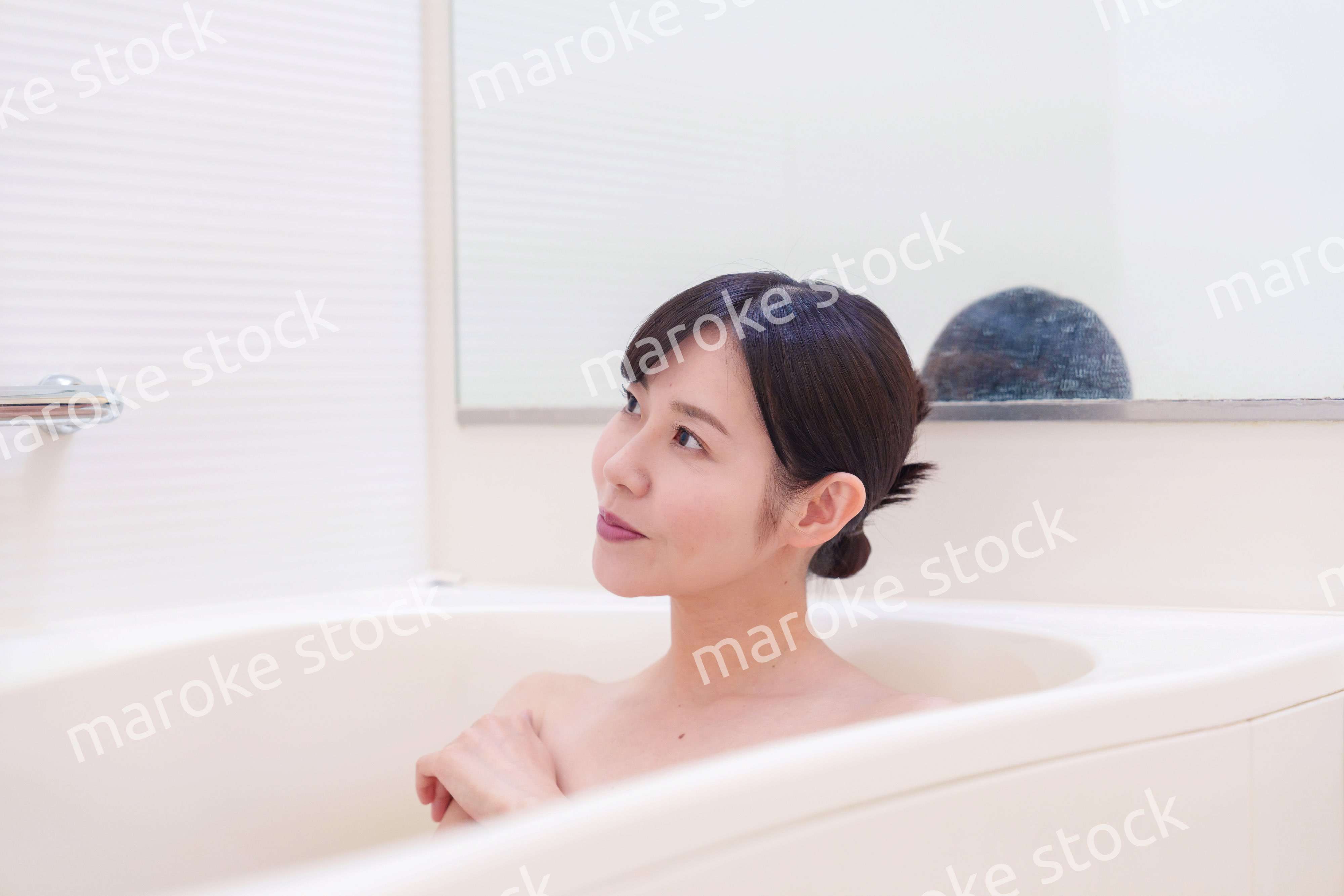 家のお風呂に入ってゆっくりとリラックスをするミドルの女性