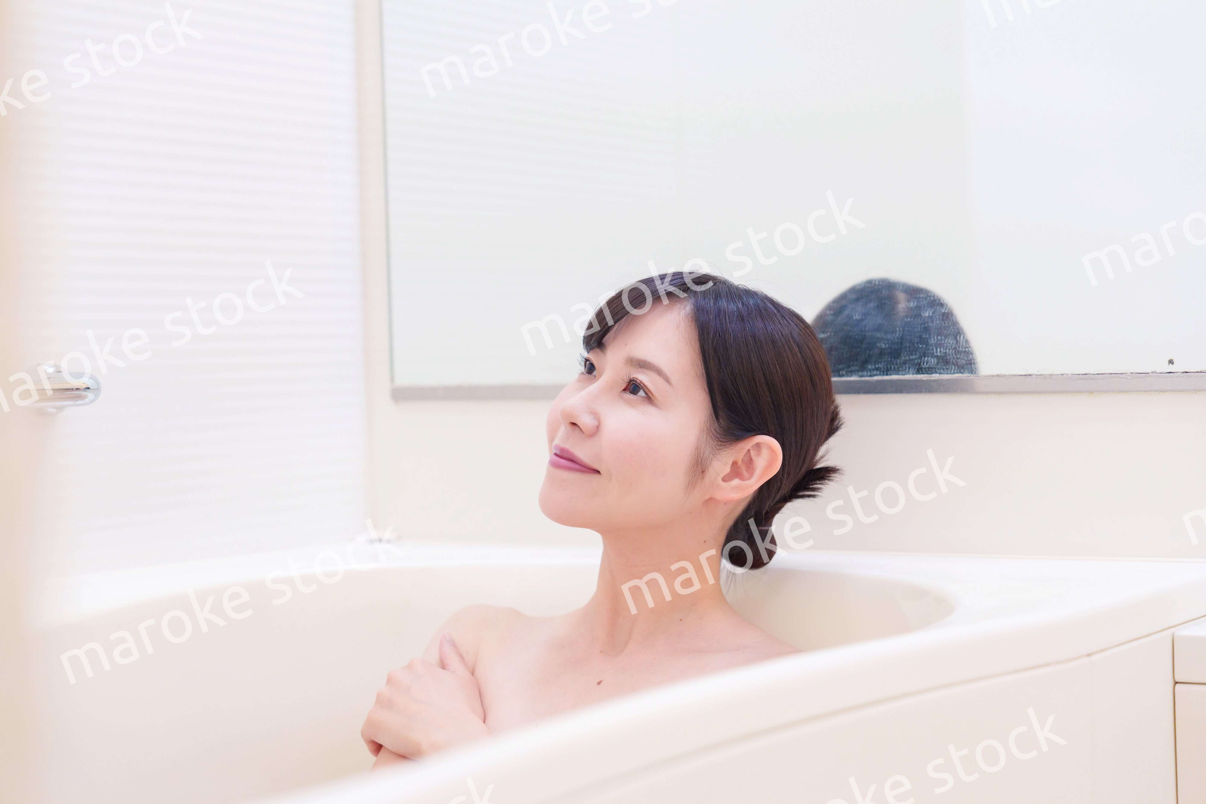 家のお風呂に入ってゆっくりとリラックスをするミドルの女性