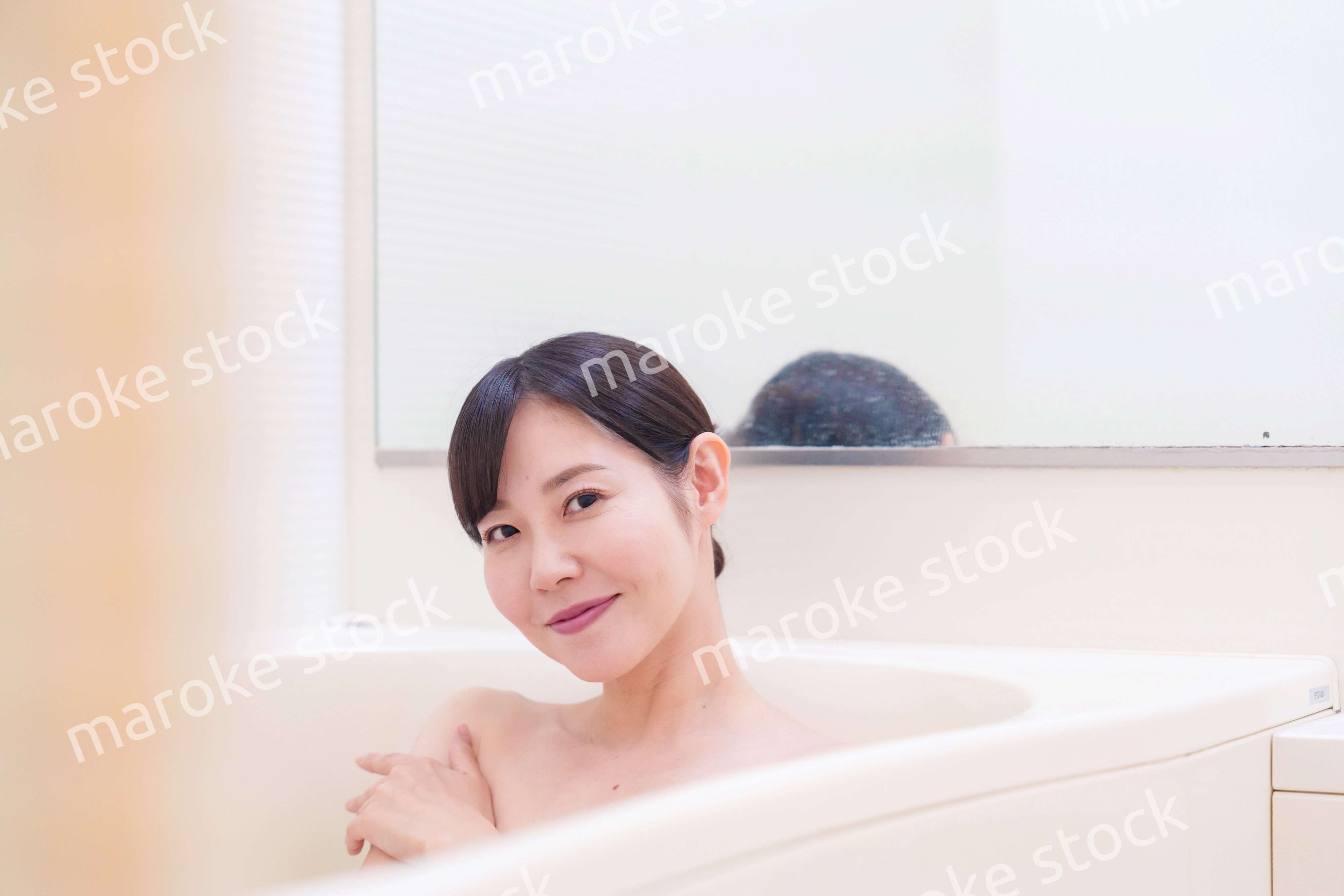 家のお風呂に入ってゆっくりとリラックスをするミドルの女性