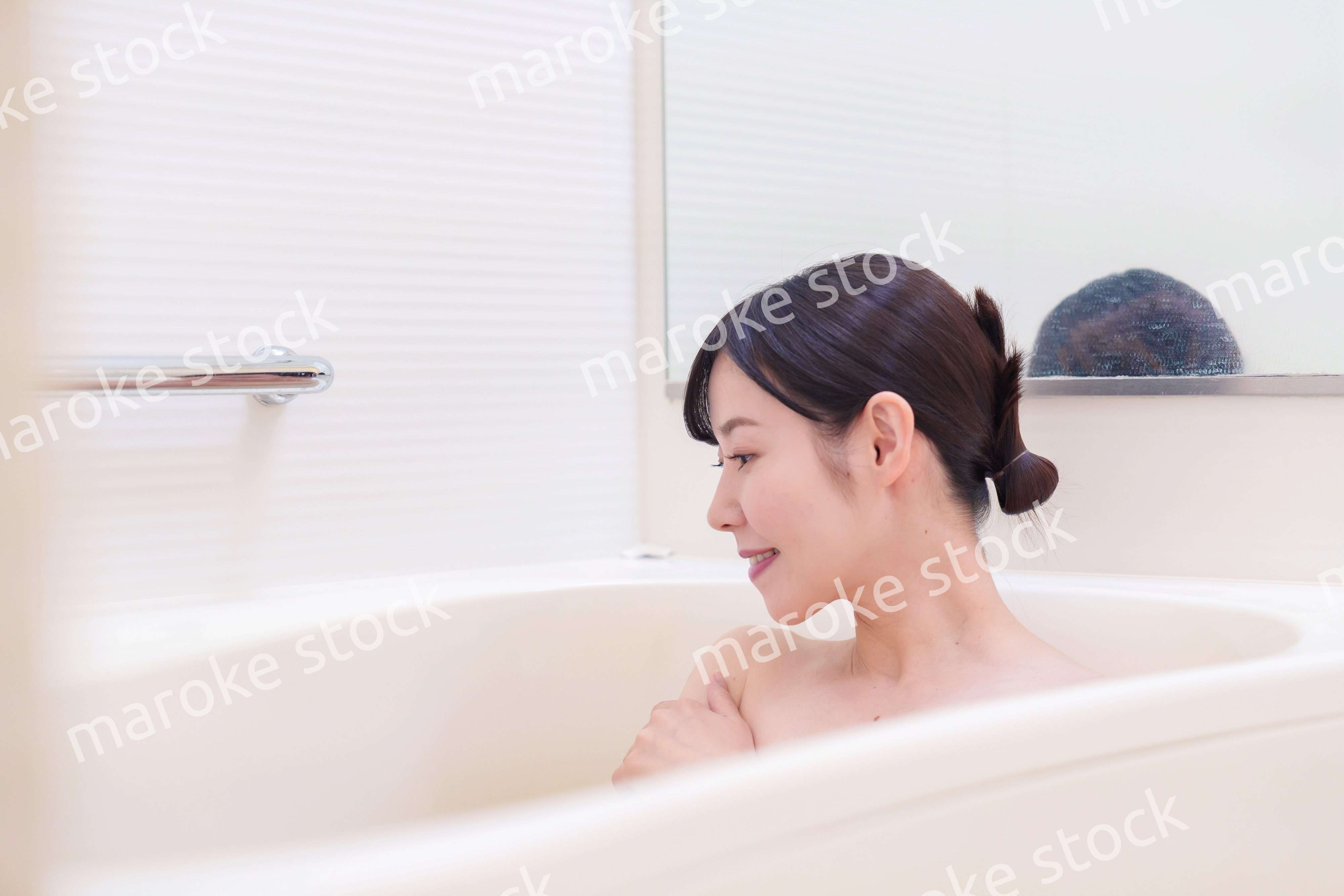 家のお風呂に入ってゆっくりとリラックスをするミドルの女性