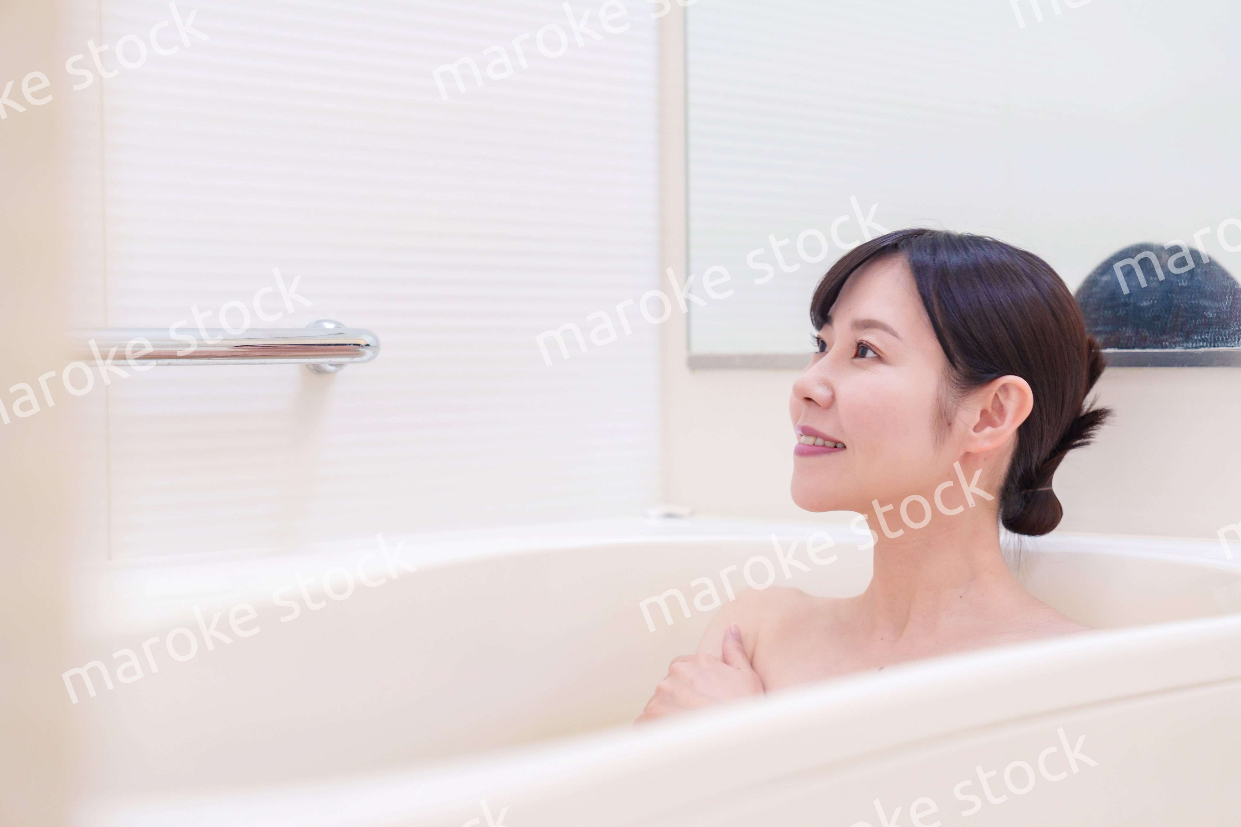 家のお風呂に入ってゆっくりとリラックスをするミドルの女性