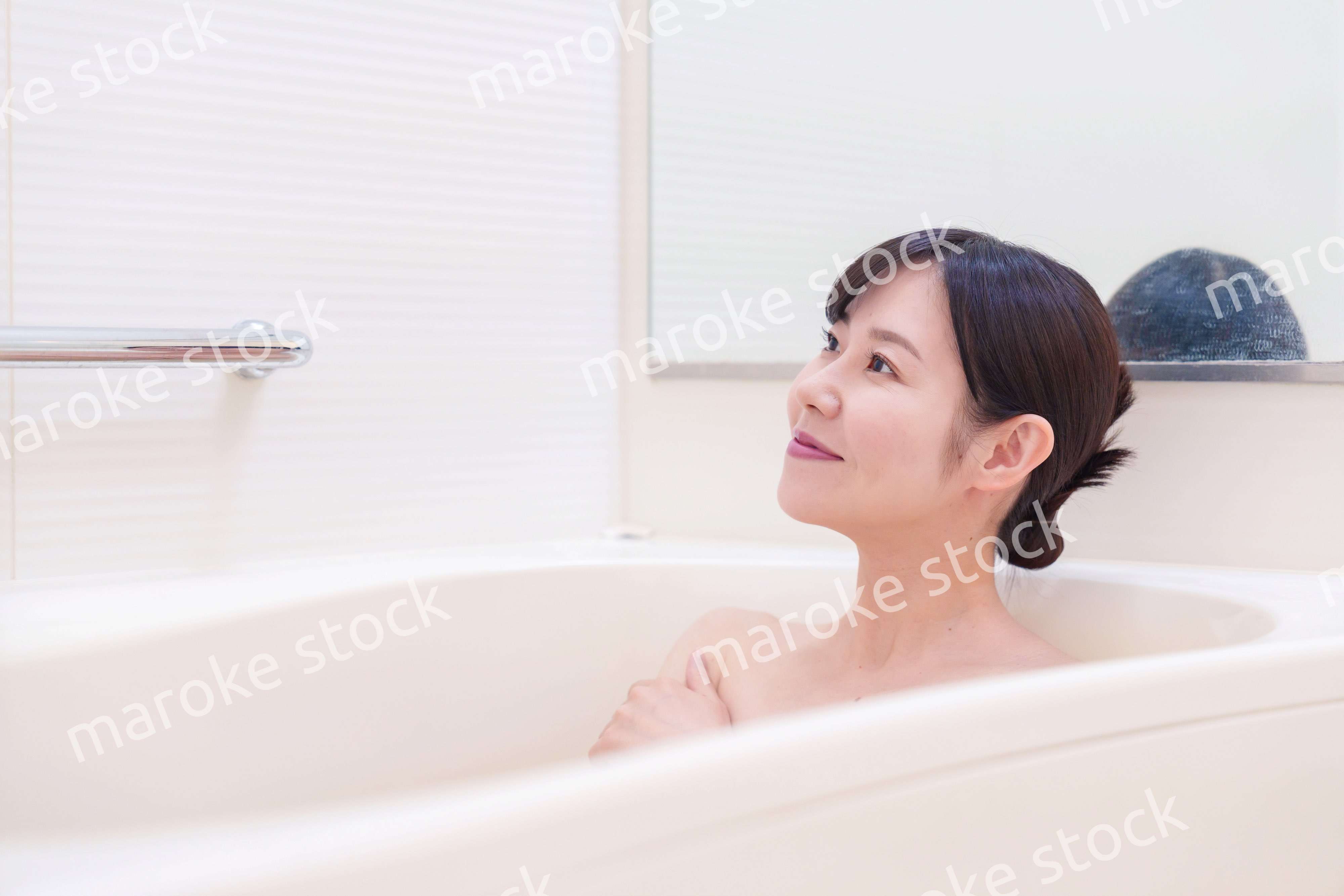 家のお風呂に入ってゆっくりとリラックスをするミドルの女性