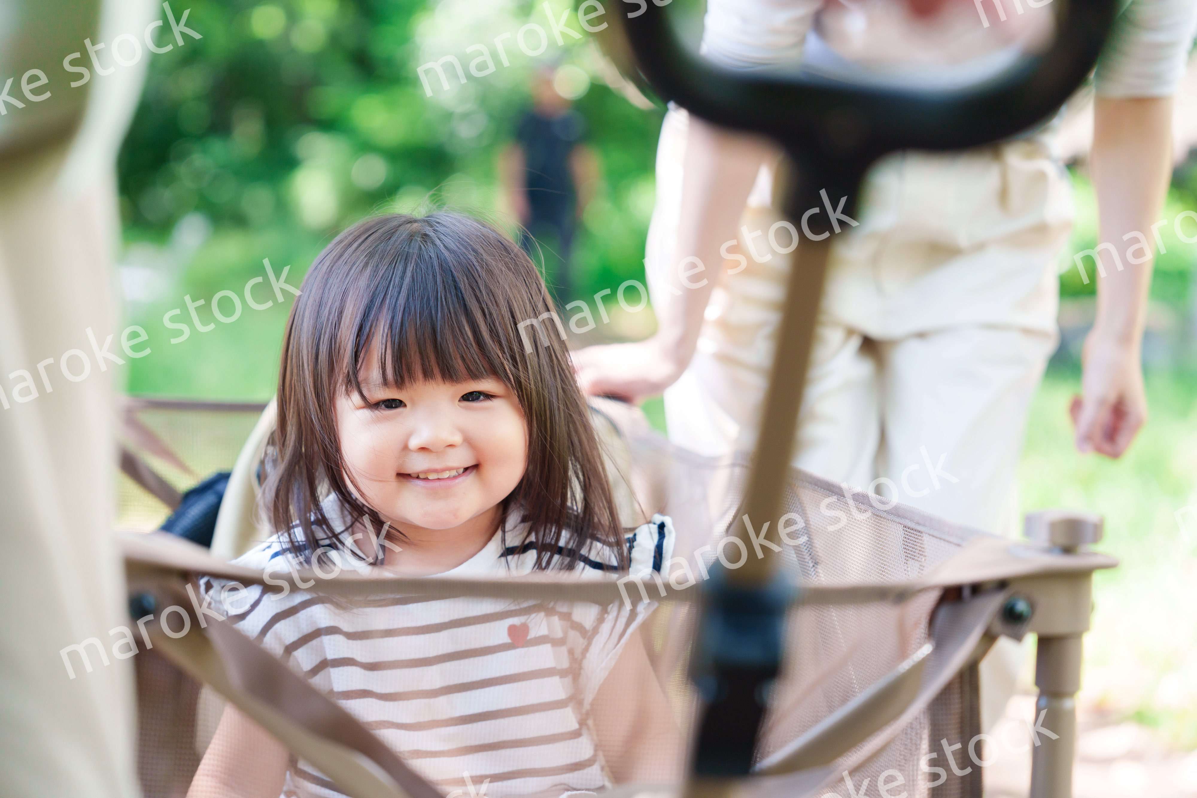 カートに乗って喜ぶ小さな女の子