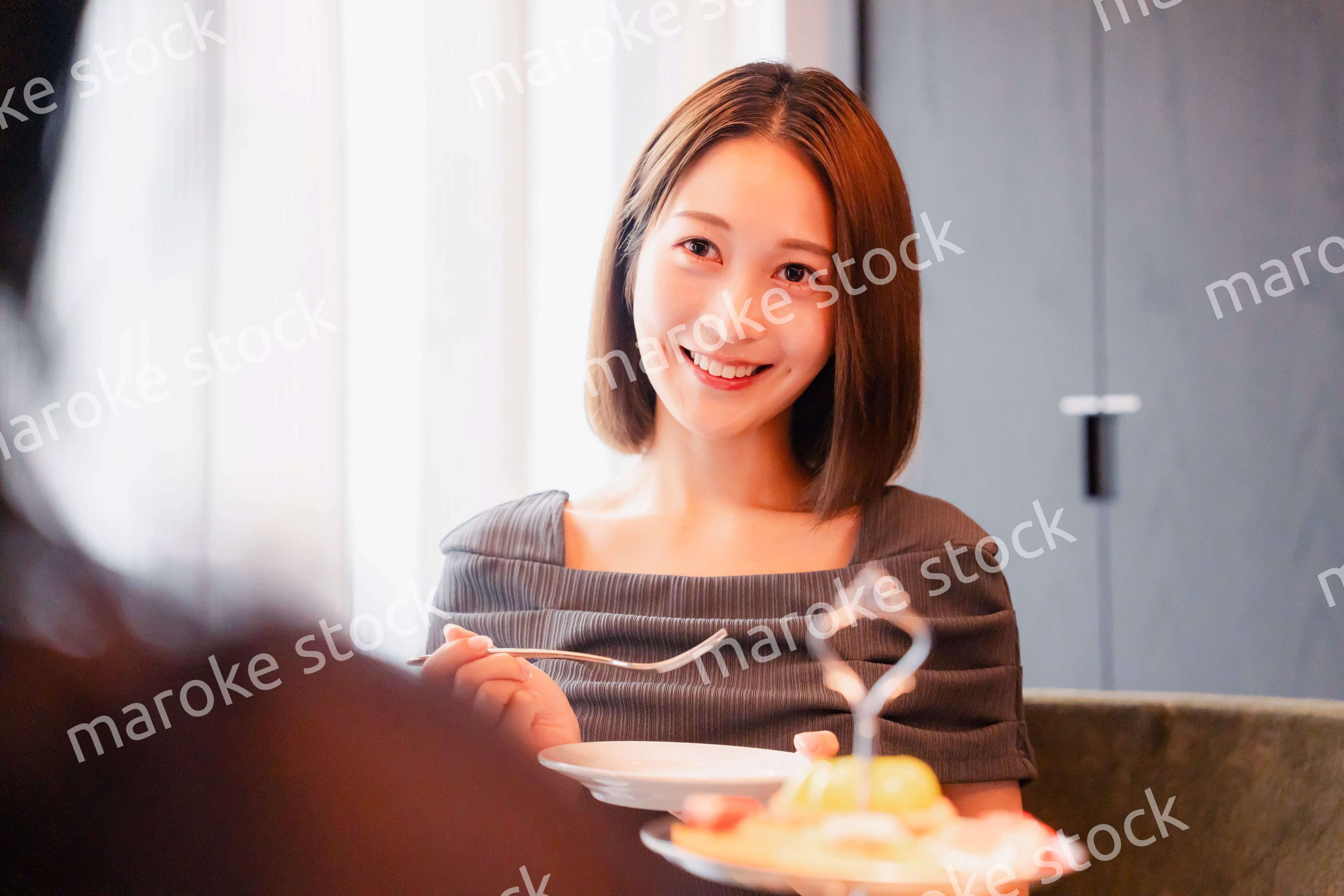 ホテルでアフタヌーンティーを楽しむ若い二人の女性