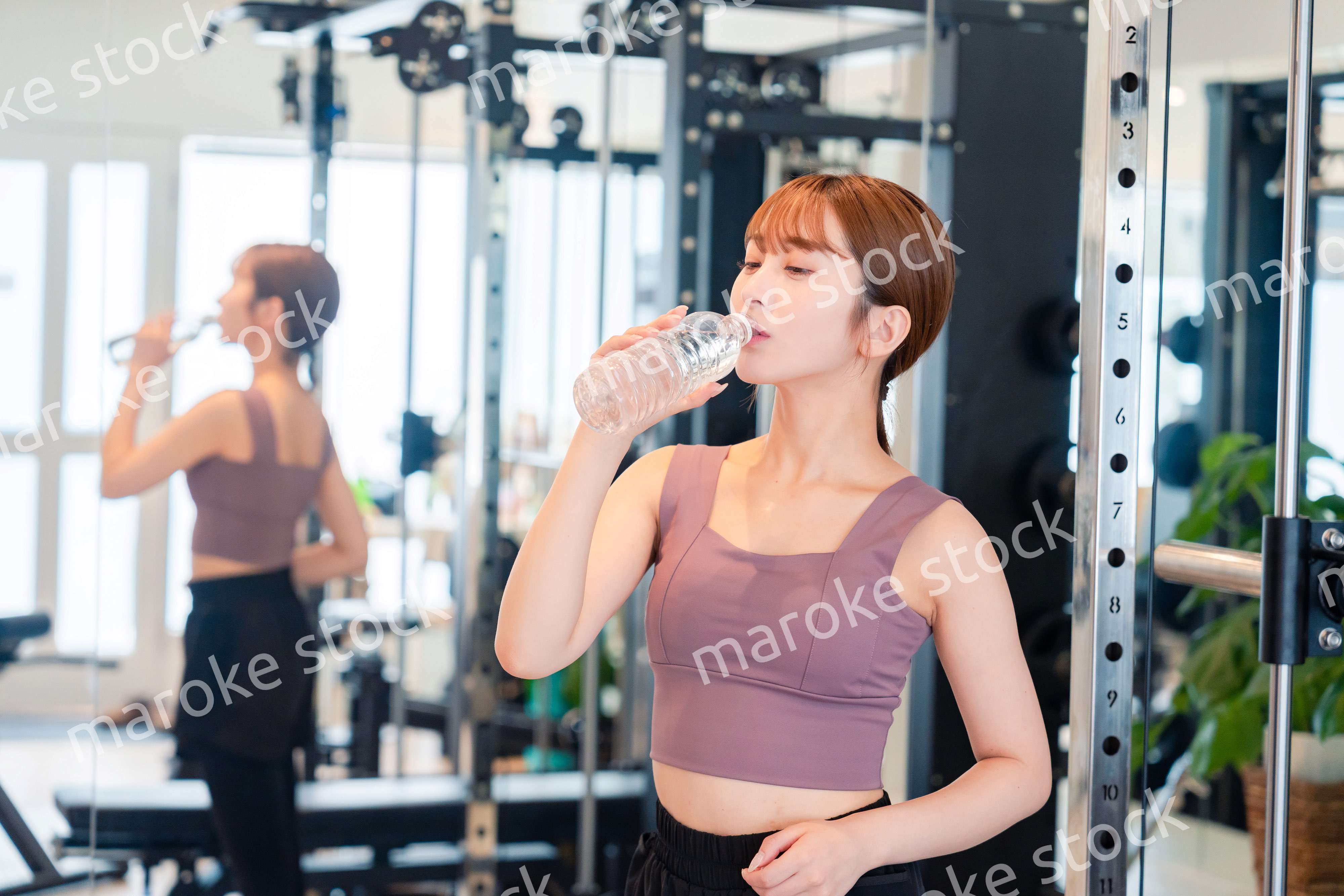 ジムで水分補給をする若い女性