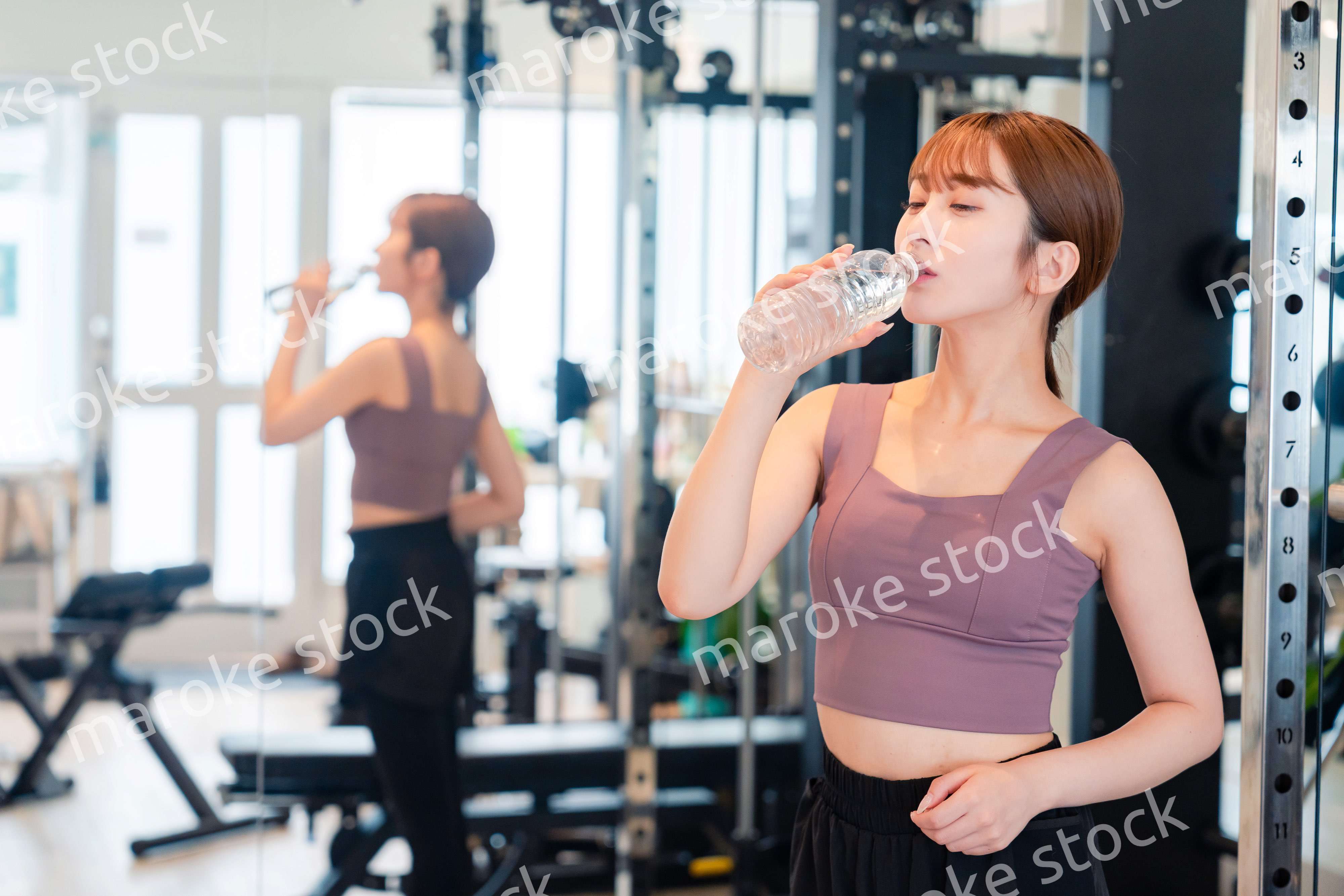 ジムで水分補給をする若い女性