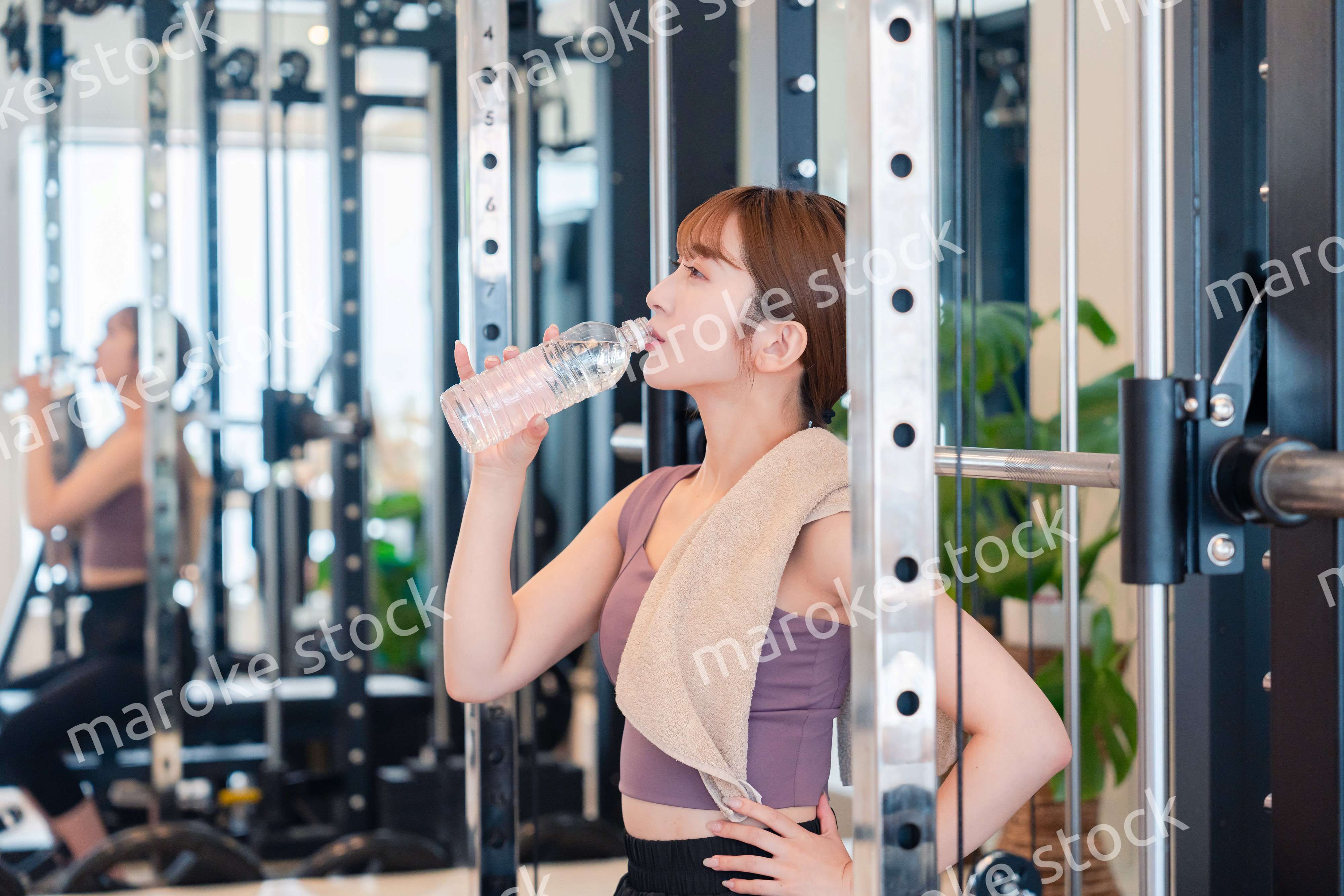 ジムで水分補給をする若い女性