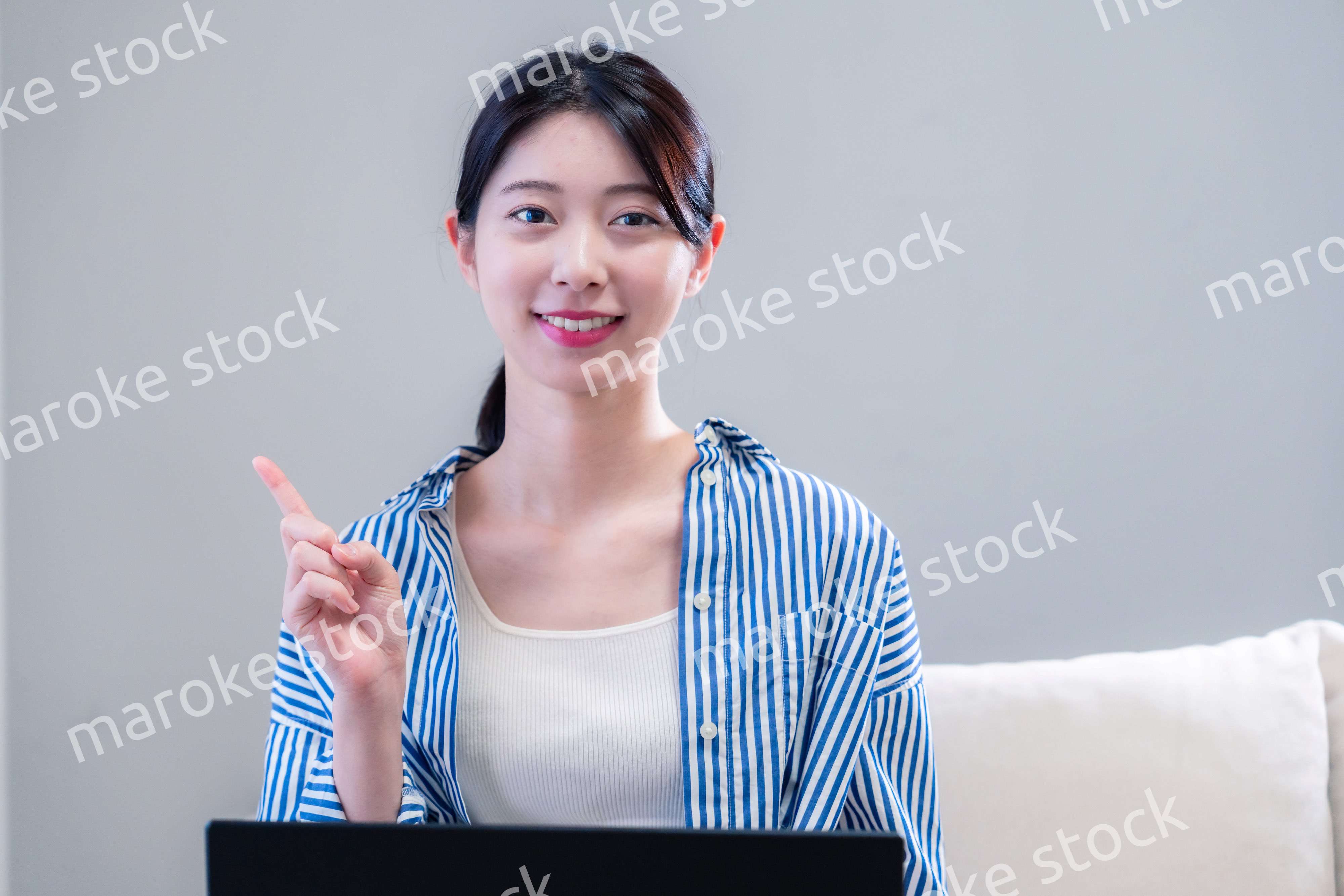 家で笑顔でパソコンを使う若い女性