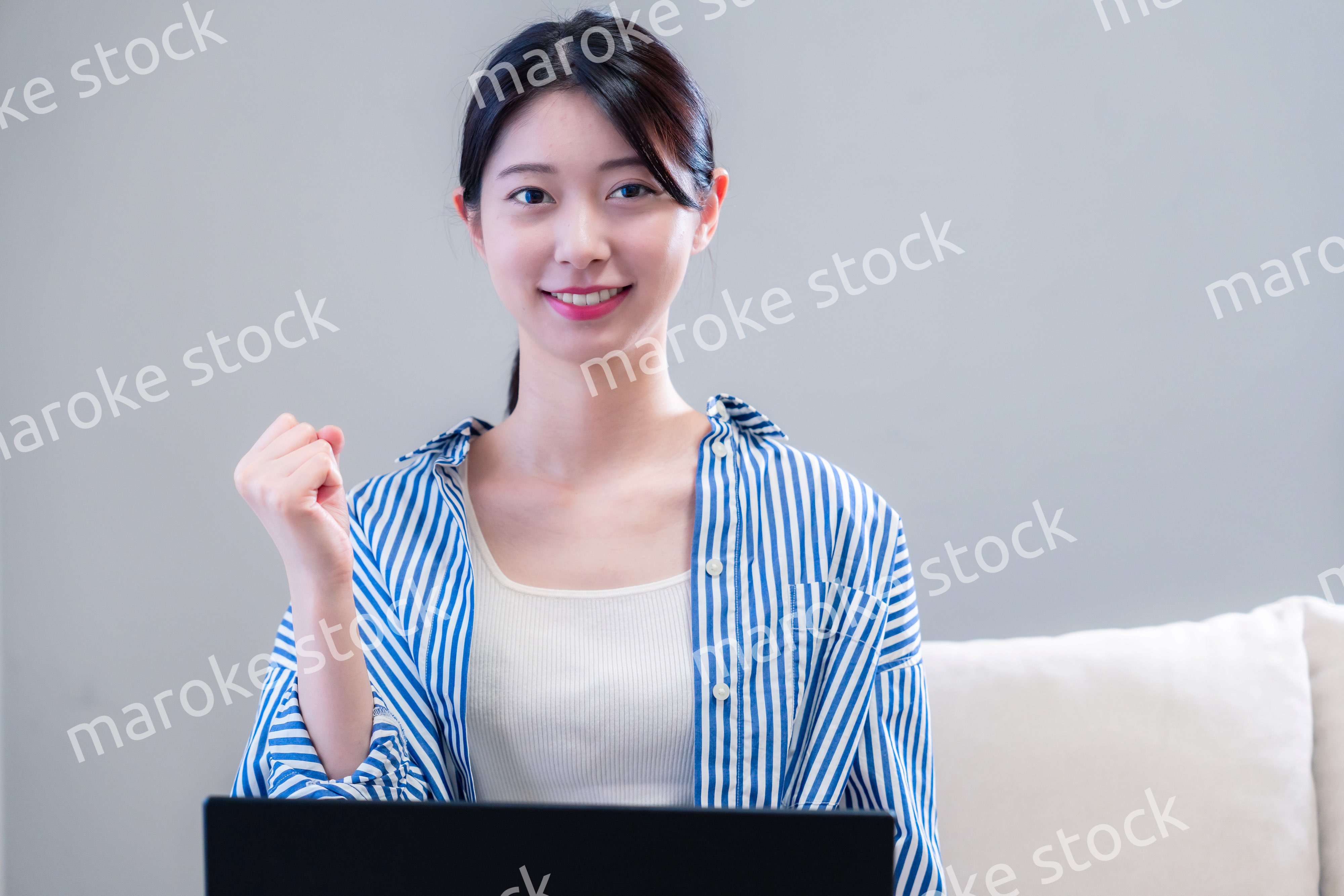 家で笑顔でパソコンを使う若い女性