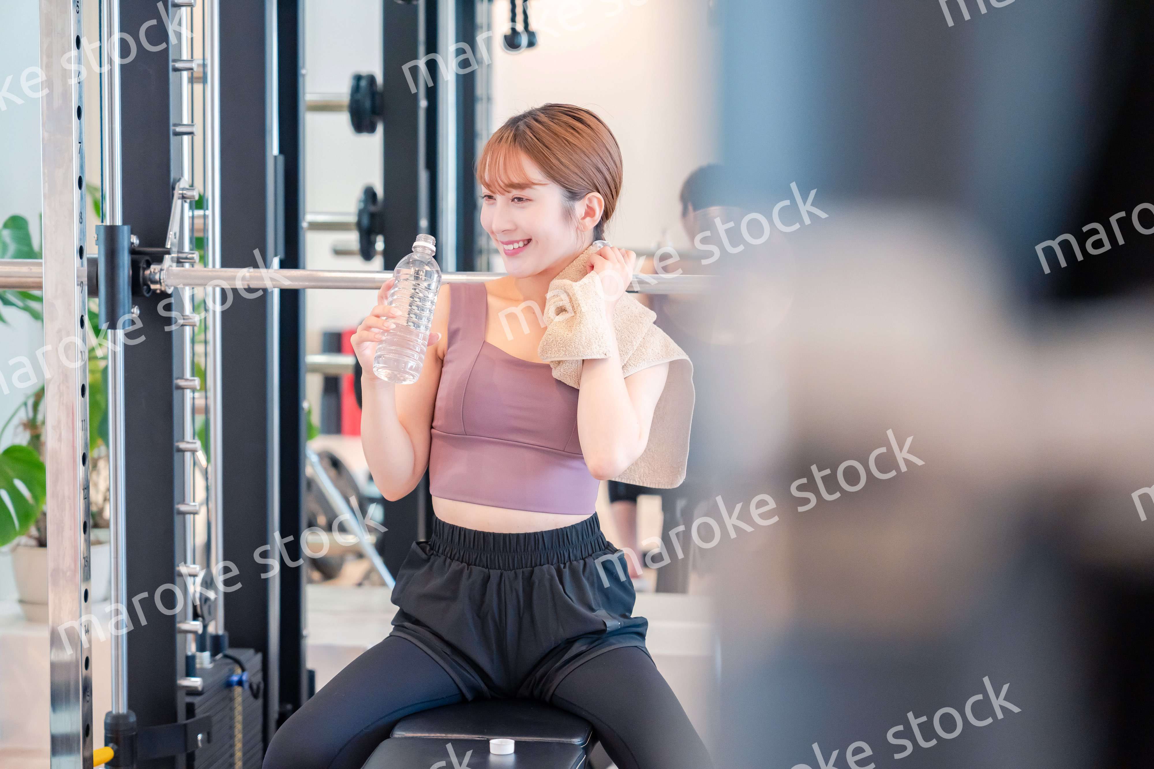 ジムで水分補給をする若い女性