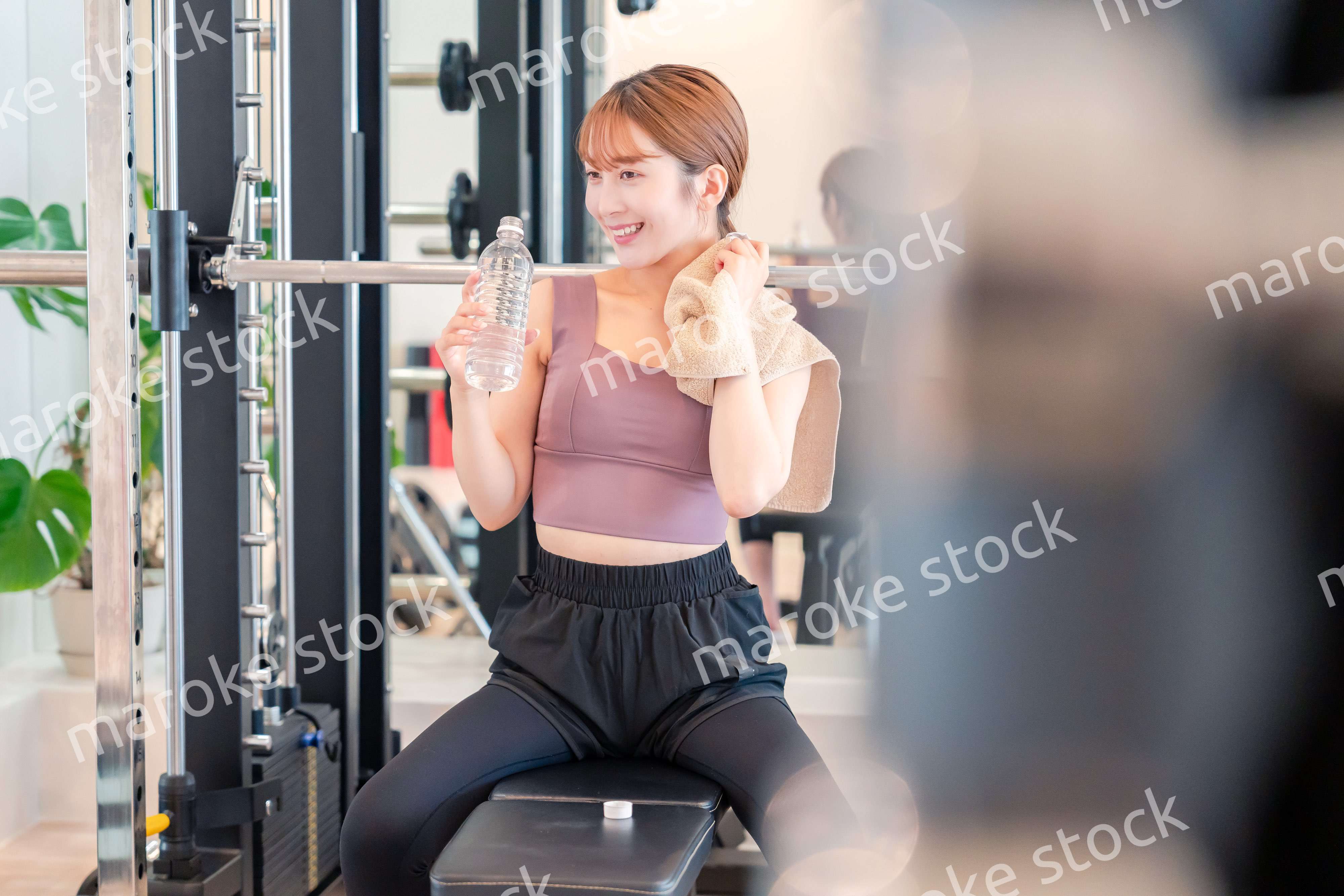 ジムで水分補給をする若い女性