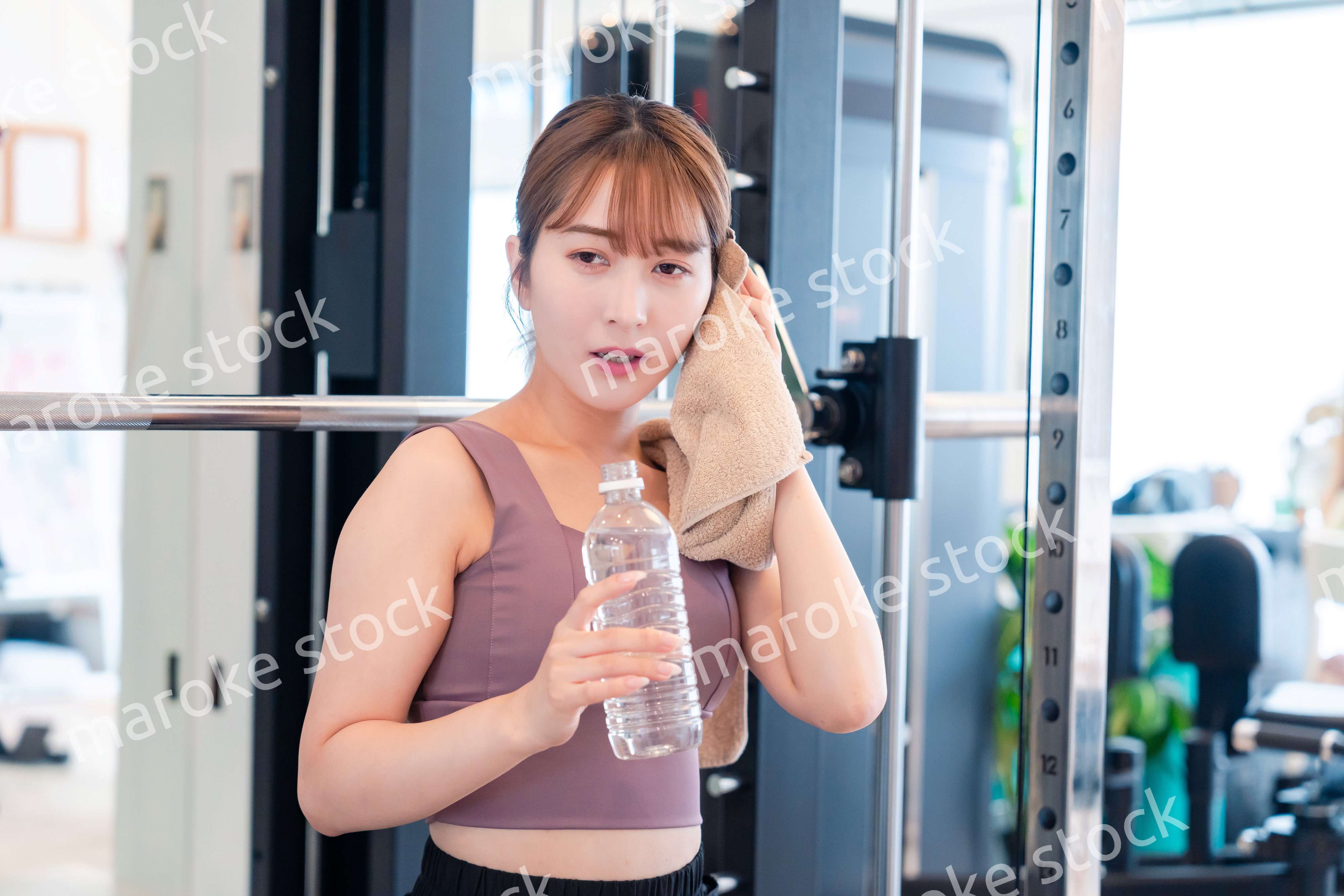 ジムで水分補給をする若い女性
