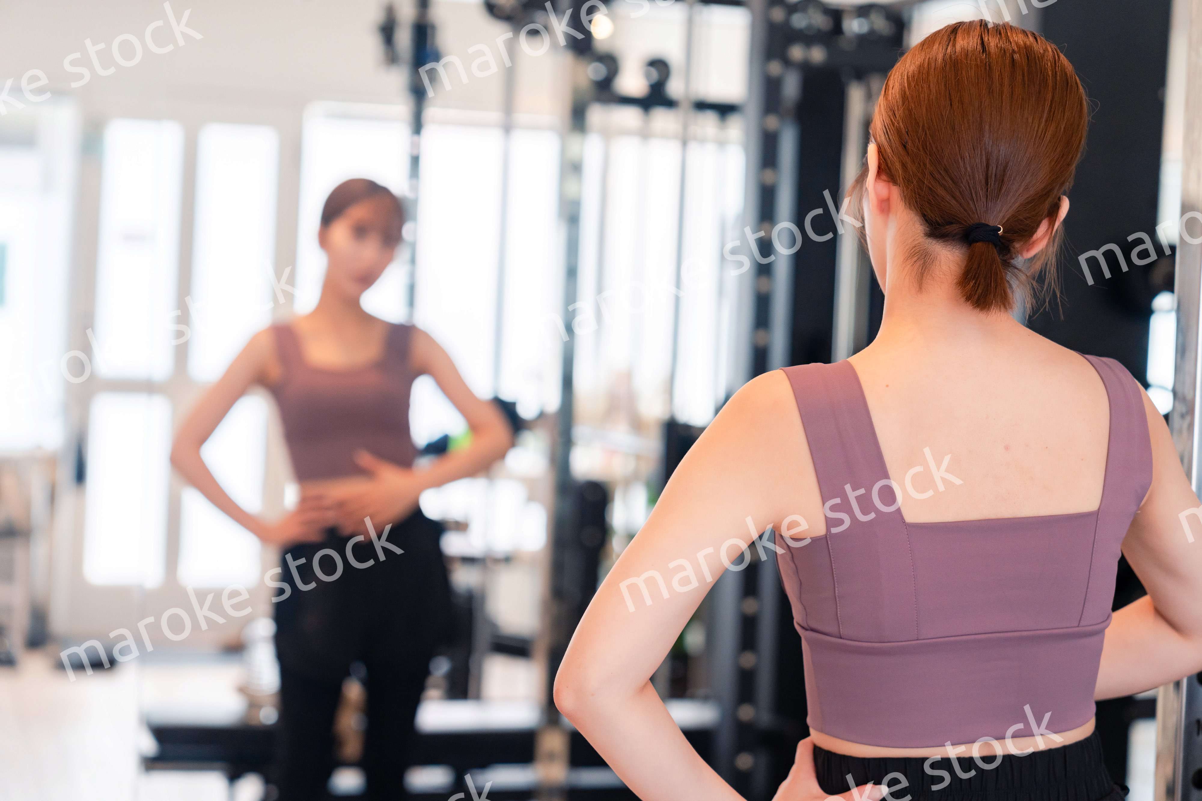 ジムで自分の体型を確認する若い女性