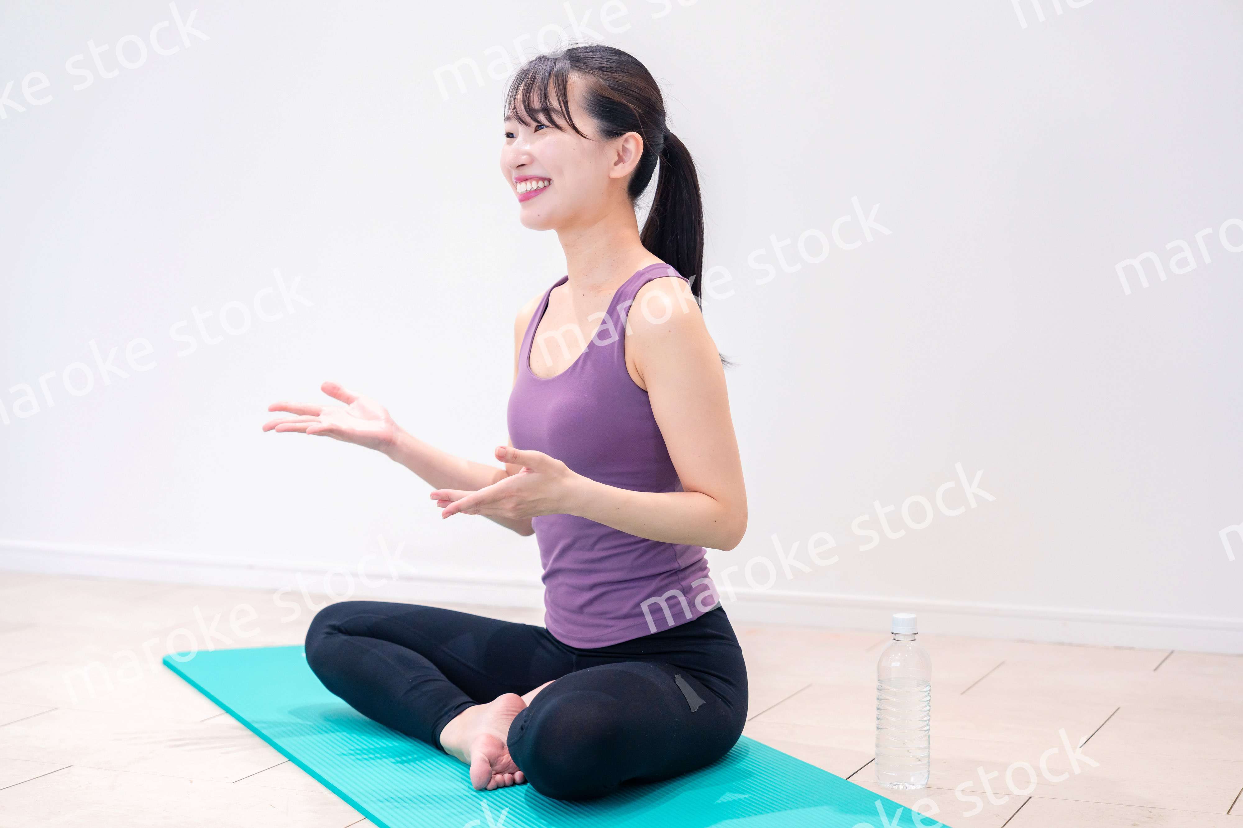 ジムでヨガコーチをするスポーティーな女性