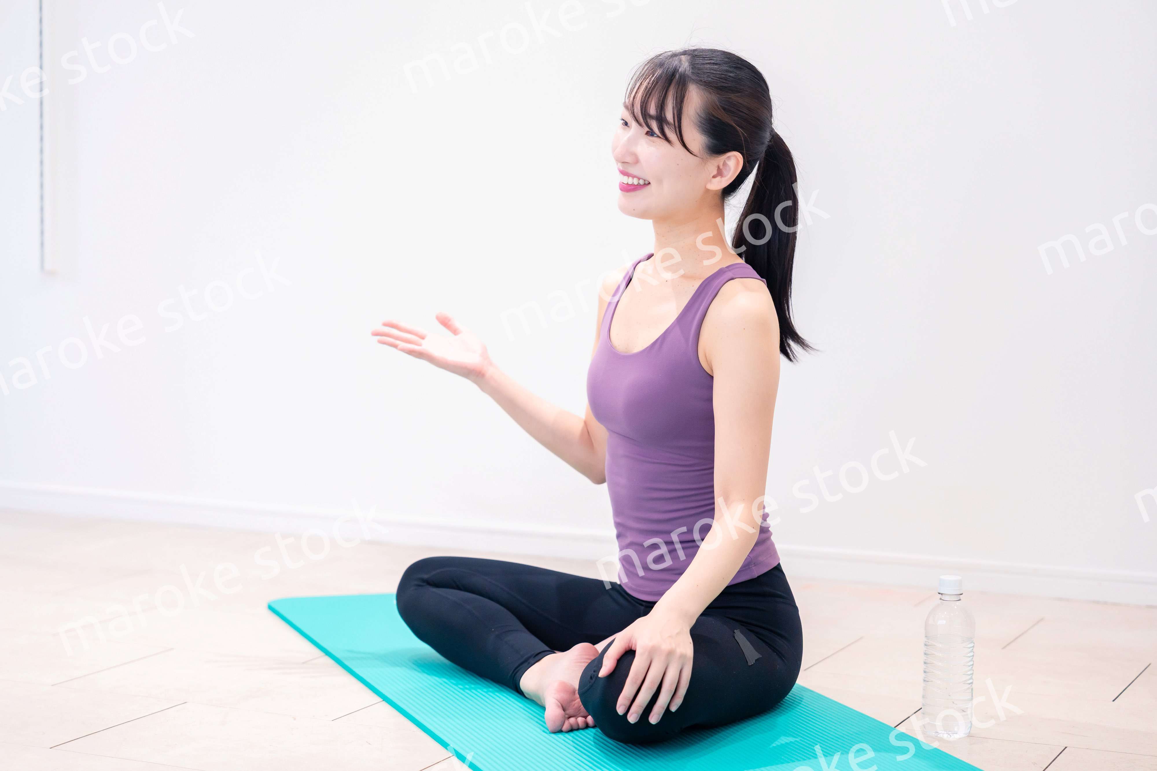 ジムでヨガコーチをするスポーティーな女性