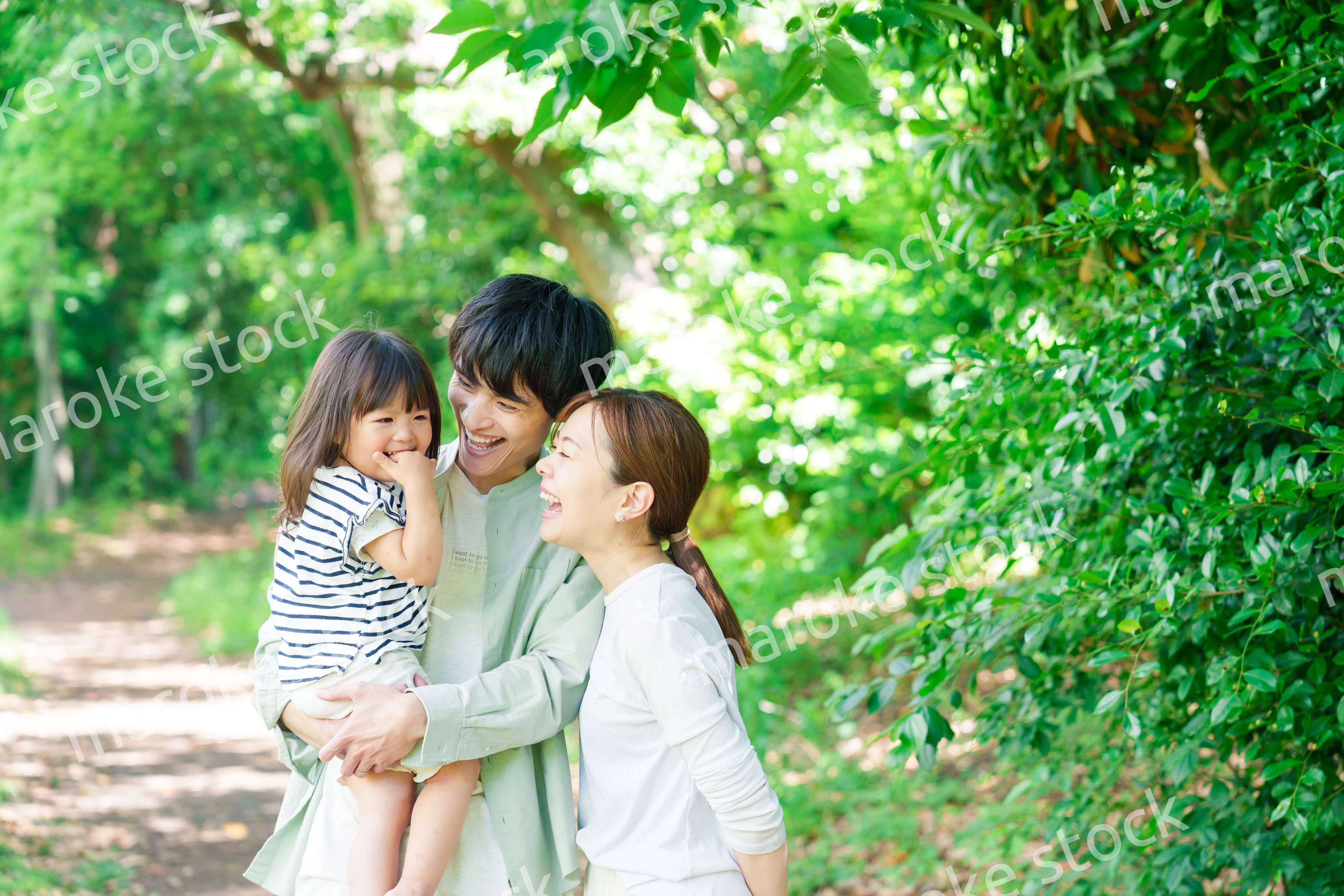 自然の中を歩いてアウトドアを楽しむ若いファミリー