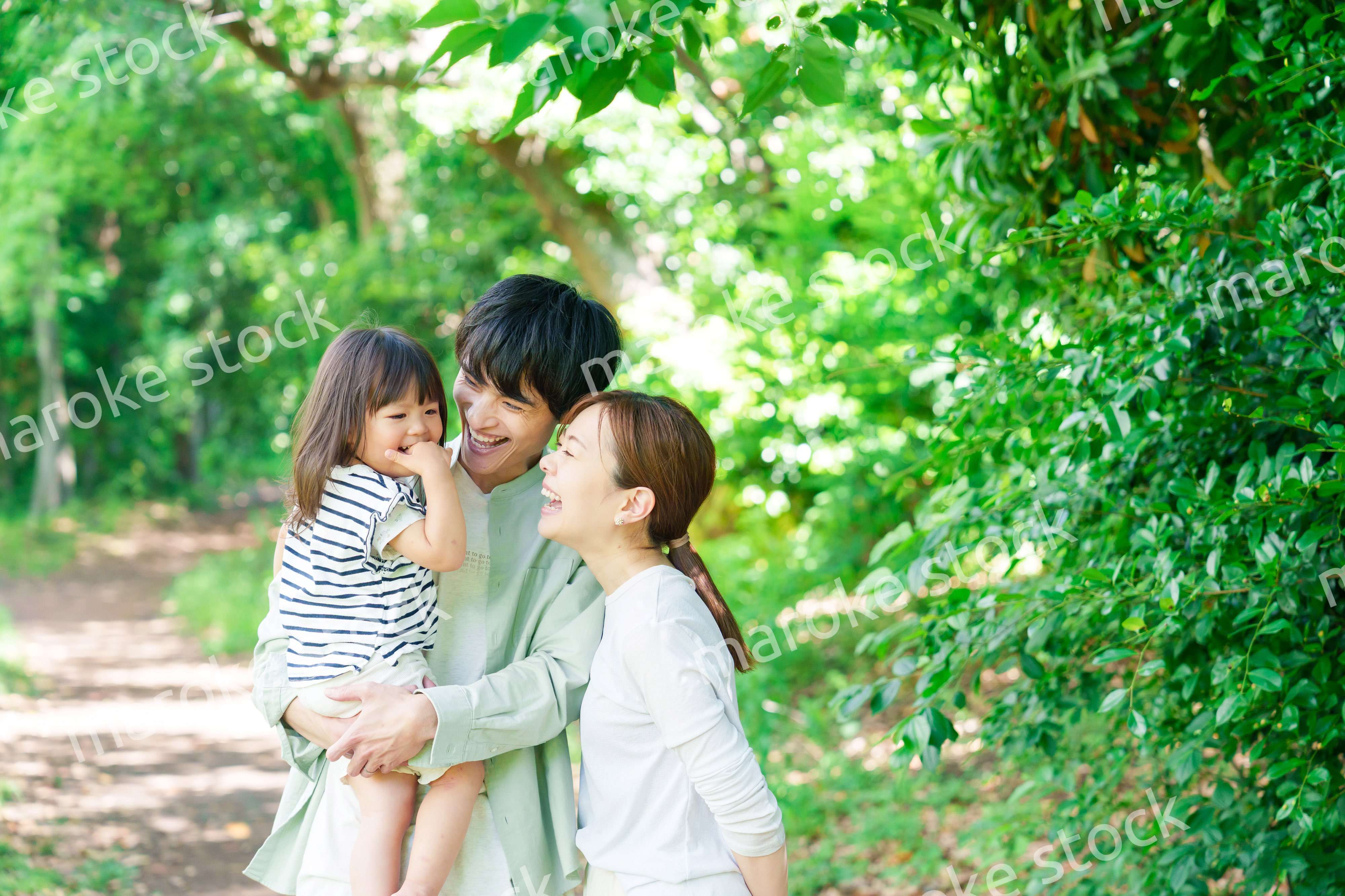 自然の中を歩いてアウトドアを楽しむ若いファミリー