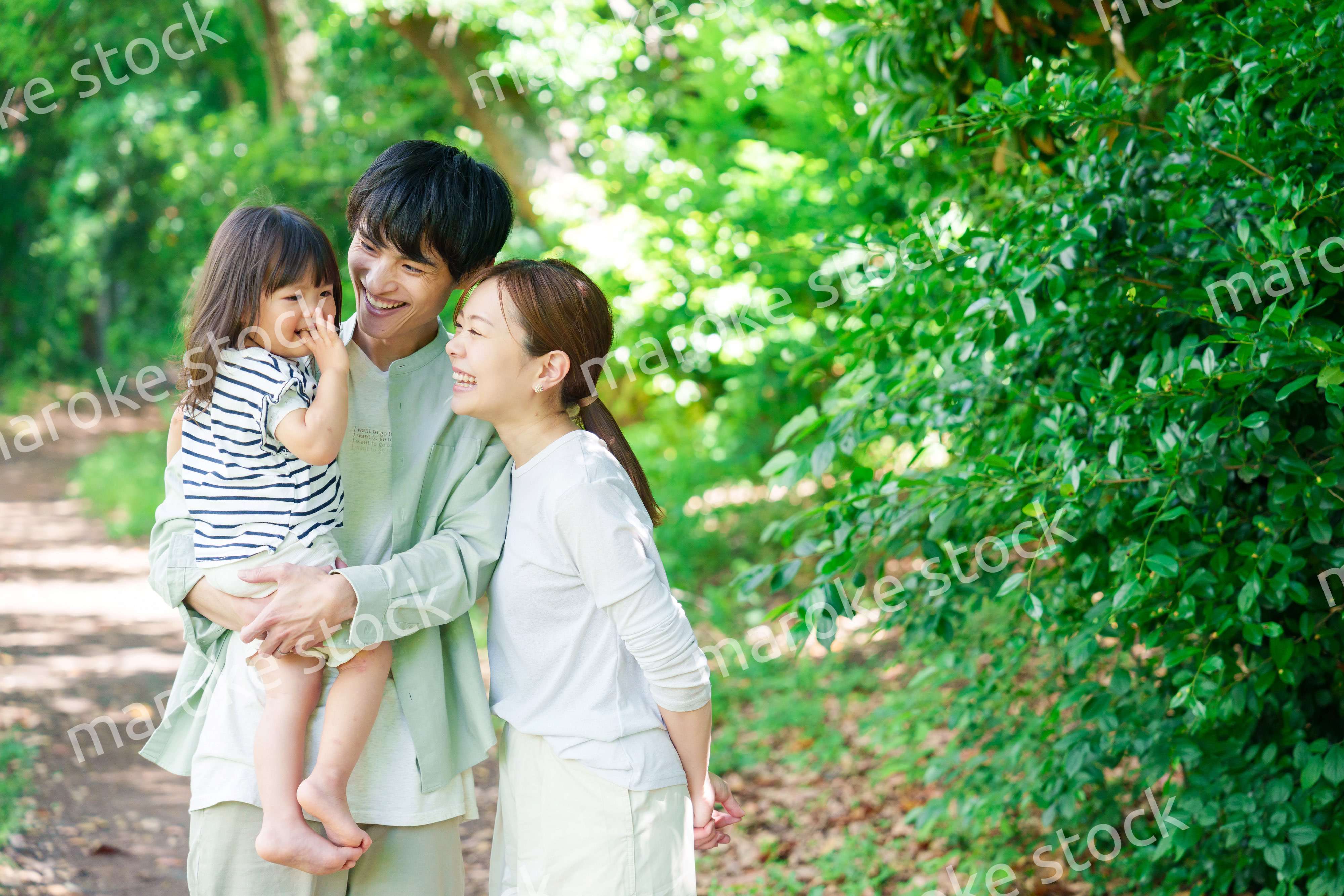 自然の中を歩いてアウトドアを楽しむ若いファミリー