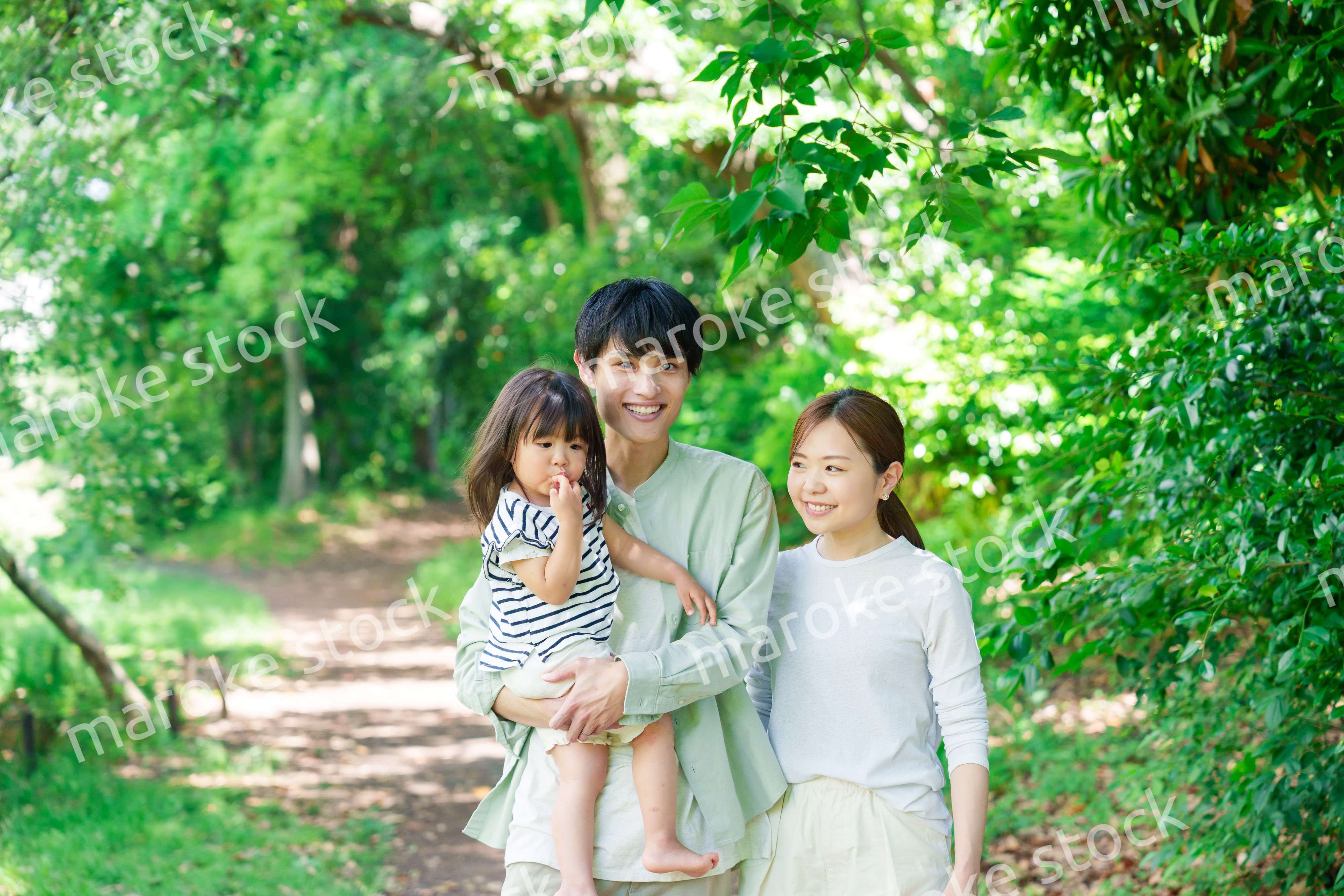 自然の中を歩いてアウトドアを楽しむ若いファミリー