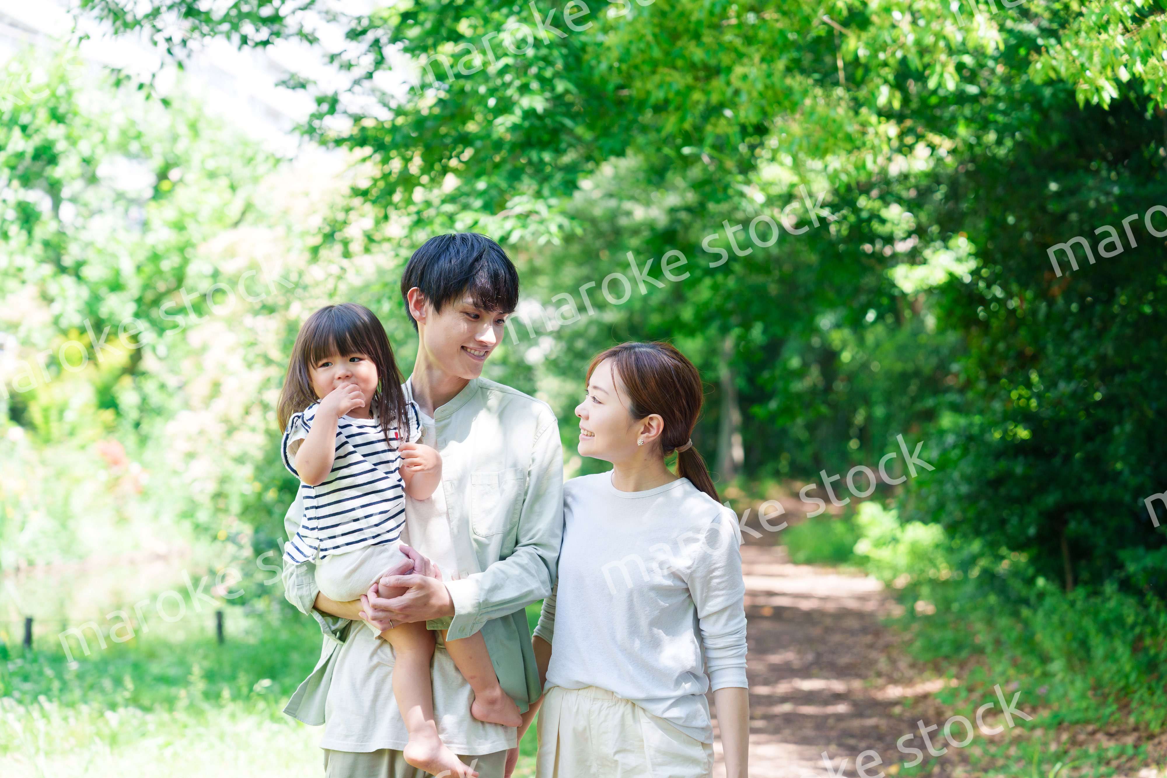 自然の中を歩いてアウトドアを楽しむ若いファミリー