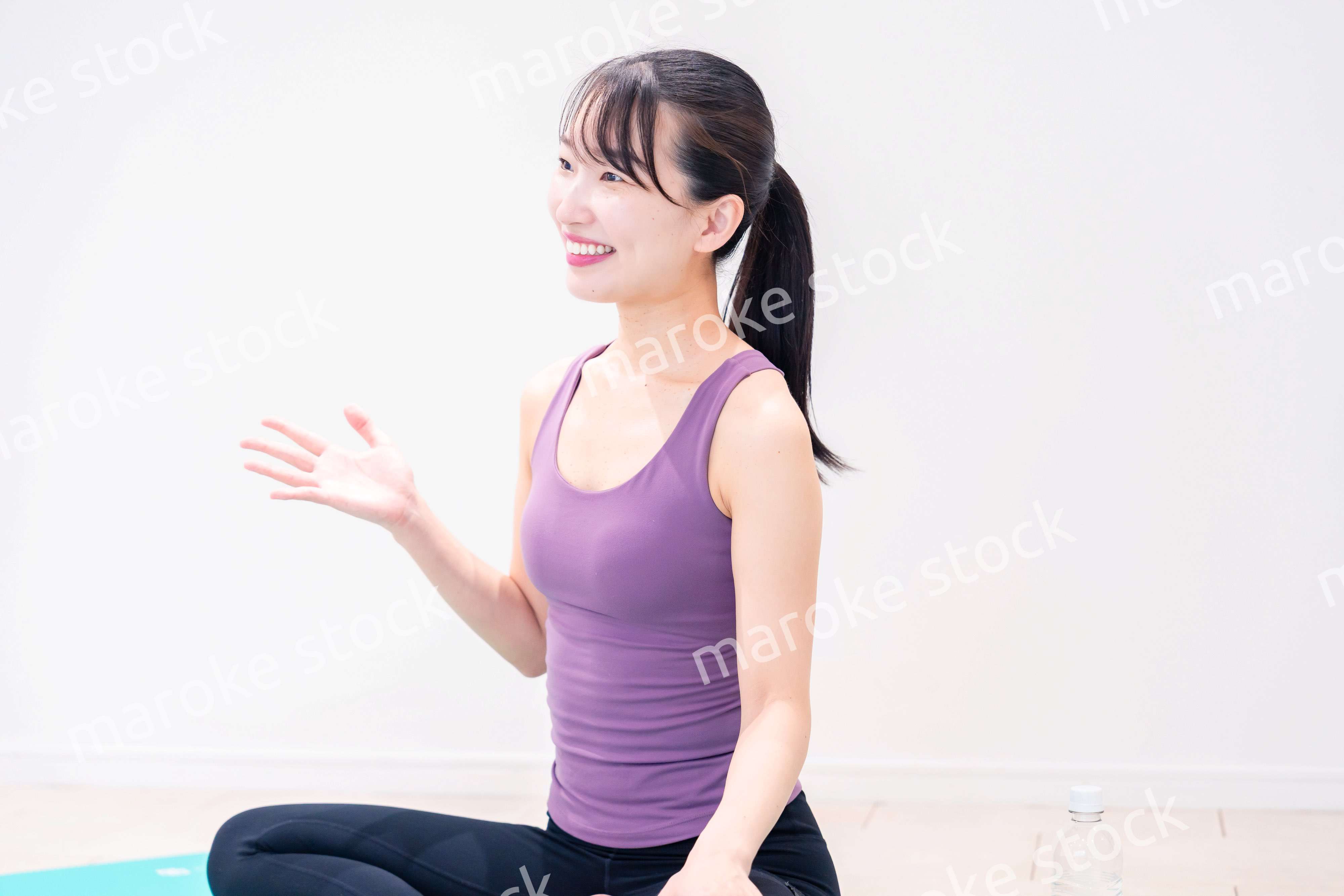 ジムでヨガコーチをするスポーティーな女性