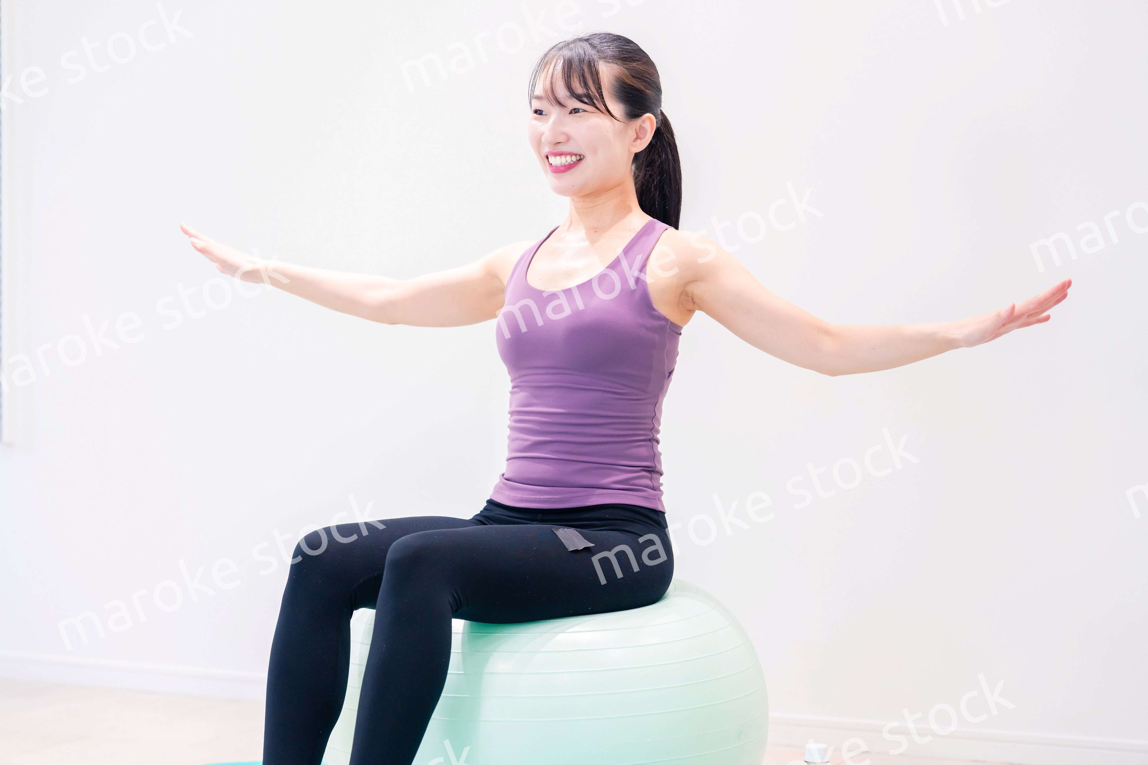 ジムでヨガコーチをするスポーティーな女性