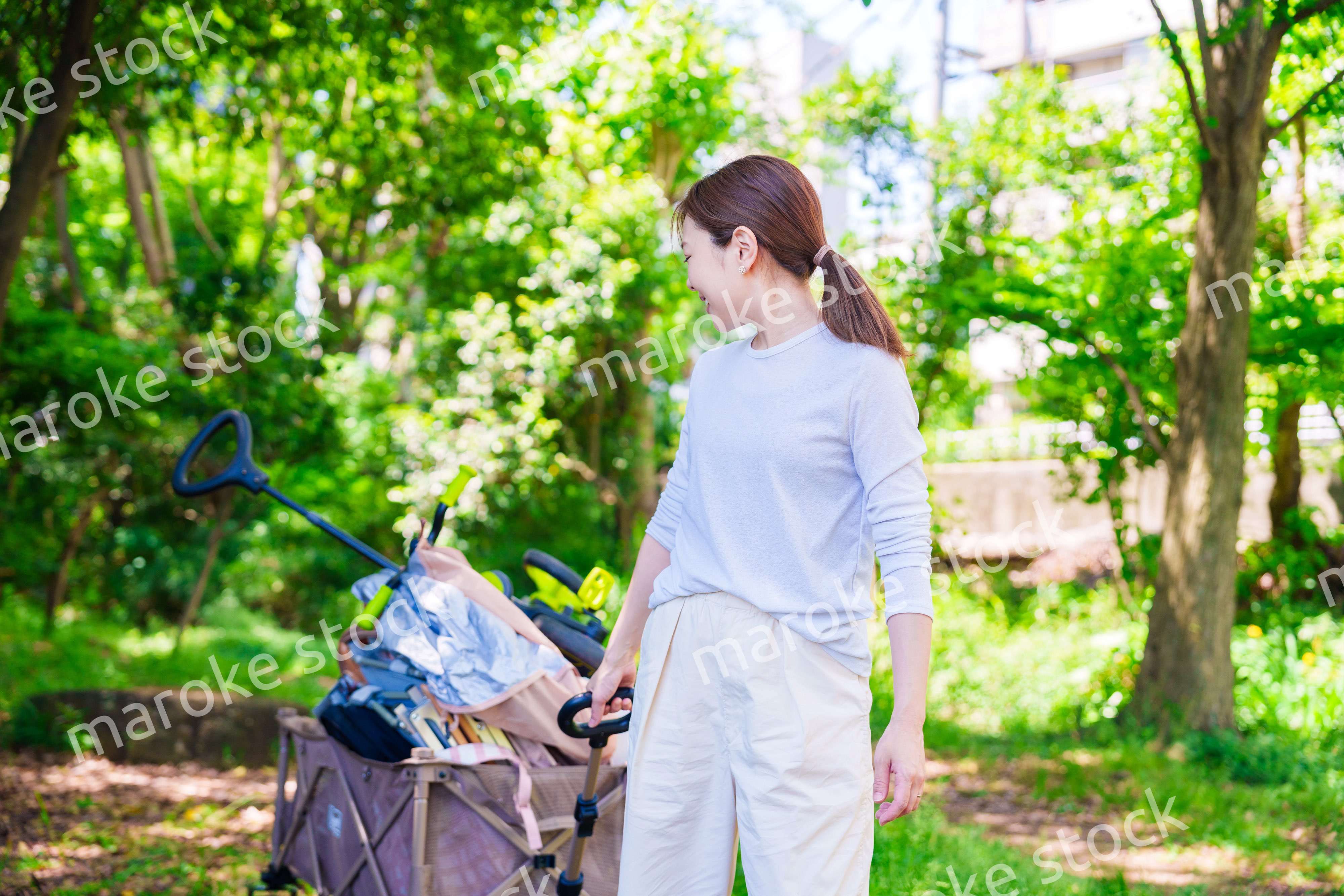 キャリアカーを引っ張ってアウトドアを楽しむ若い女性