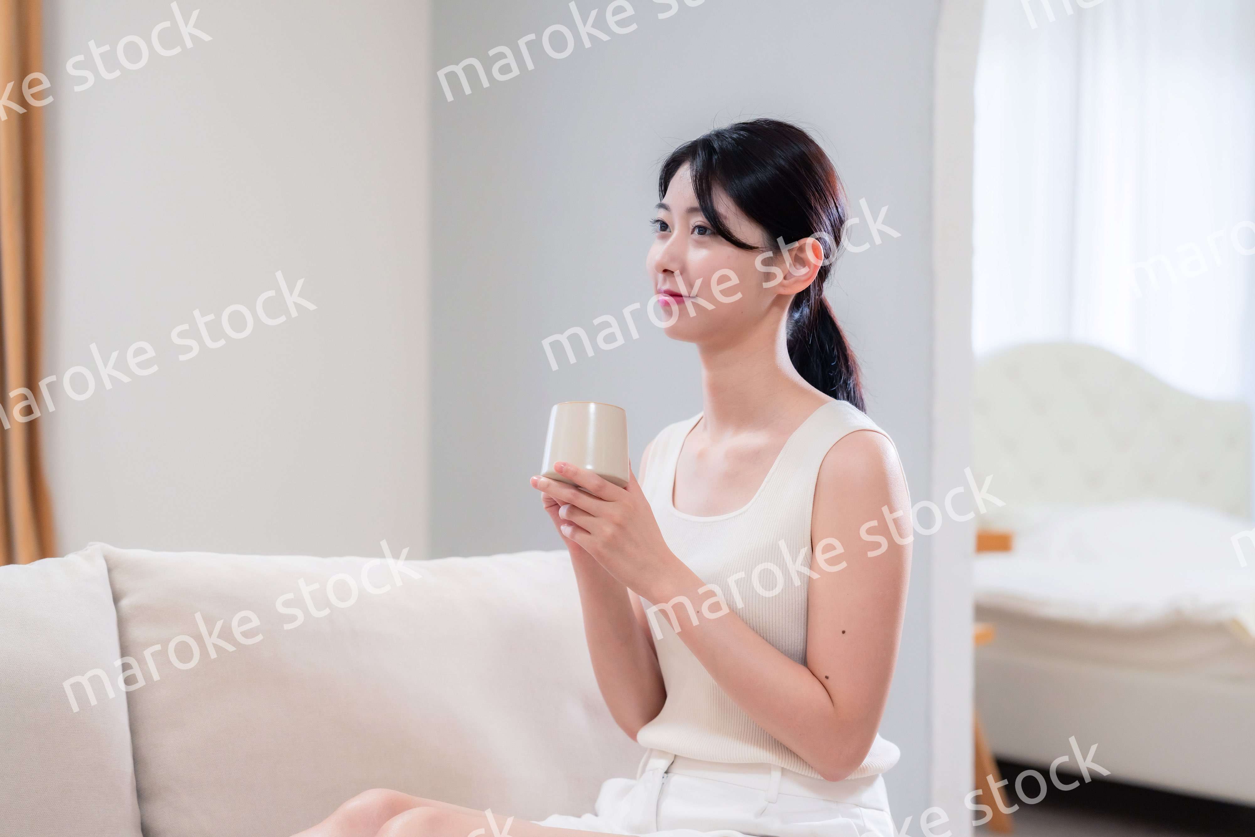 家でソファに座ってリラックスをする若い女性