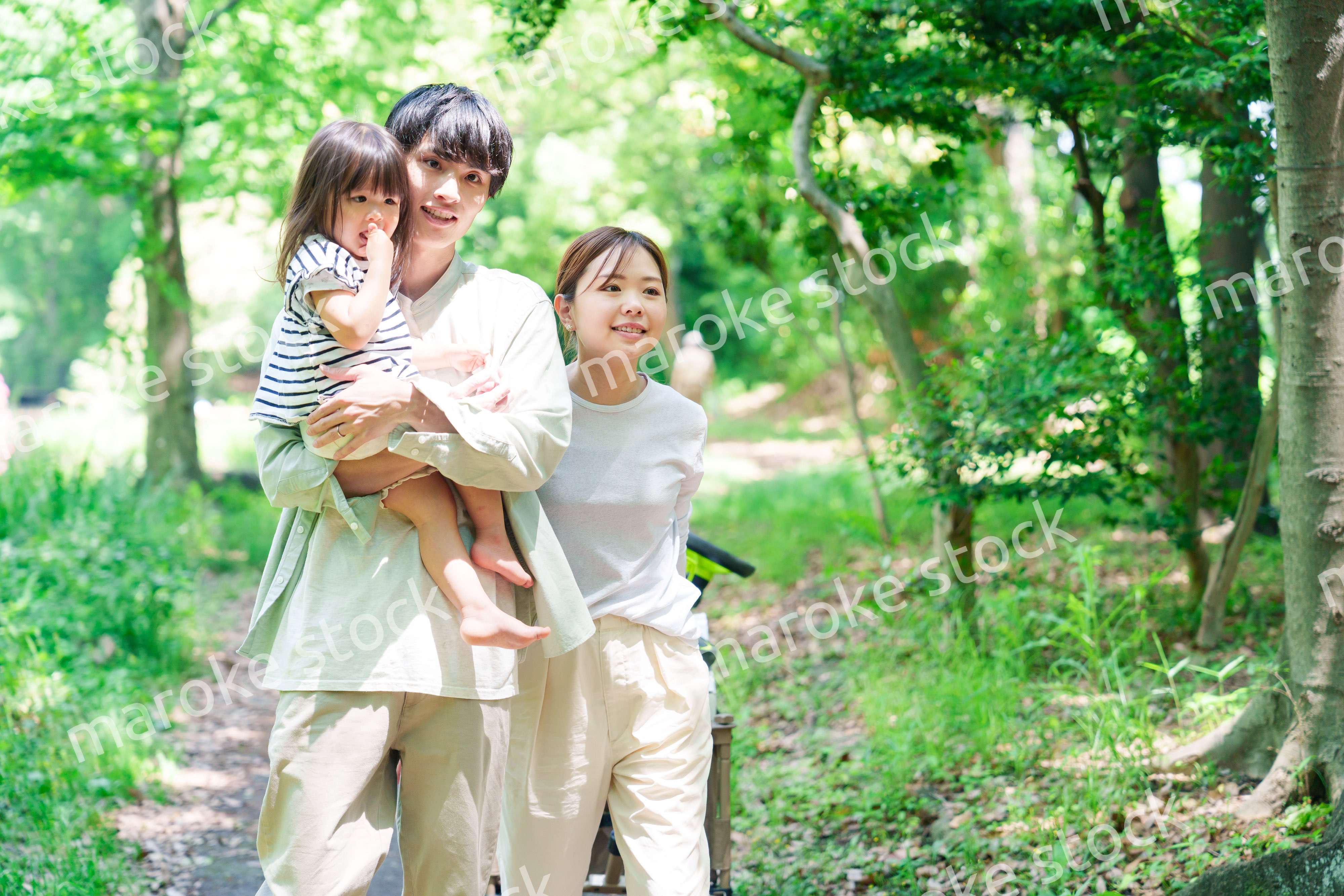 自然の中を歩いてアウトドアを楽しむ若いファミリー