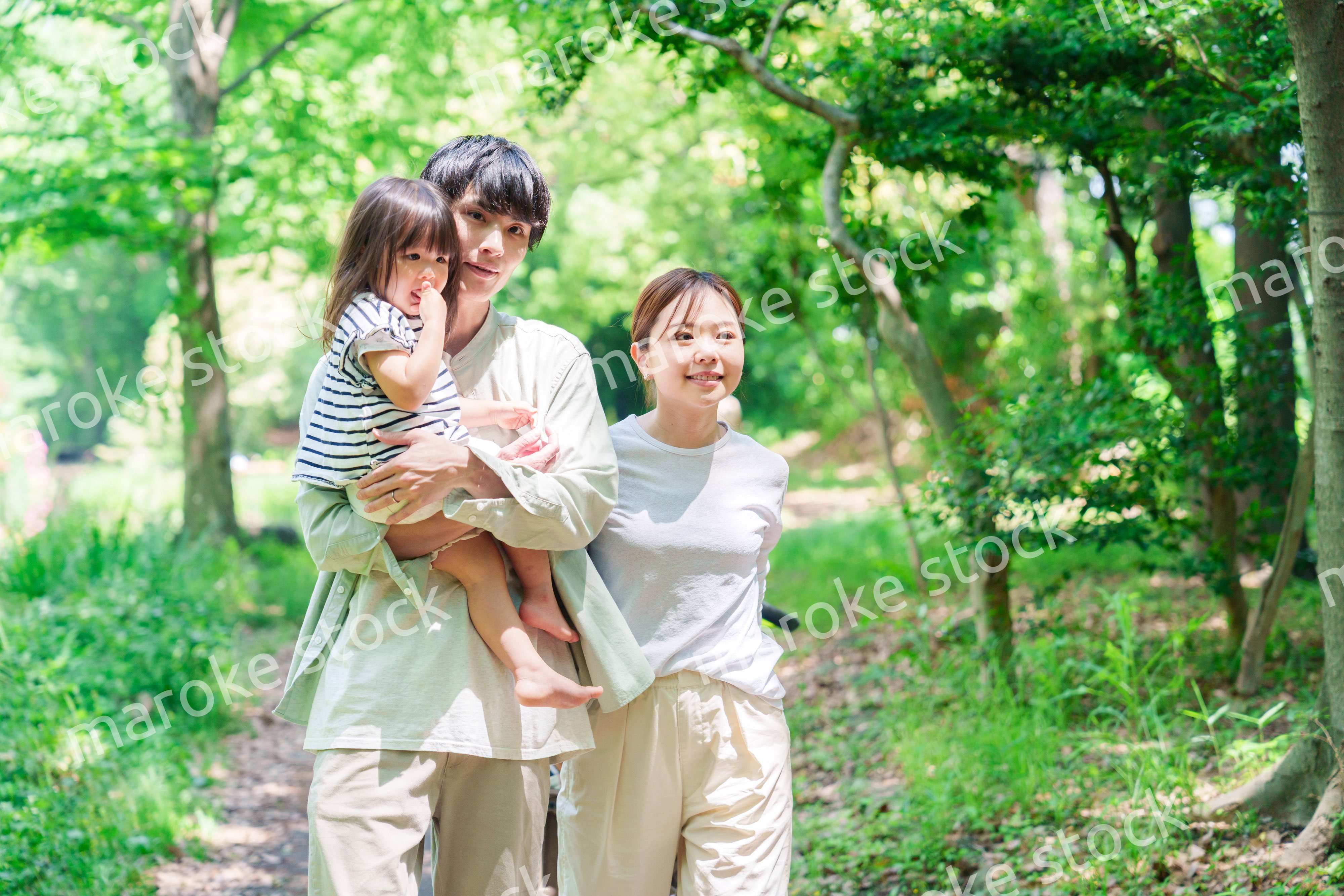 自然の中を歩いてアウトドアを楽しむ若いファミリー