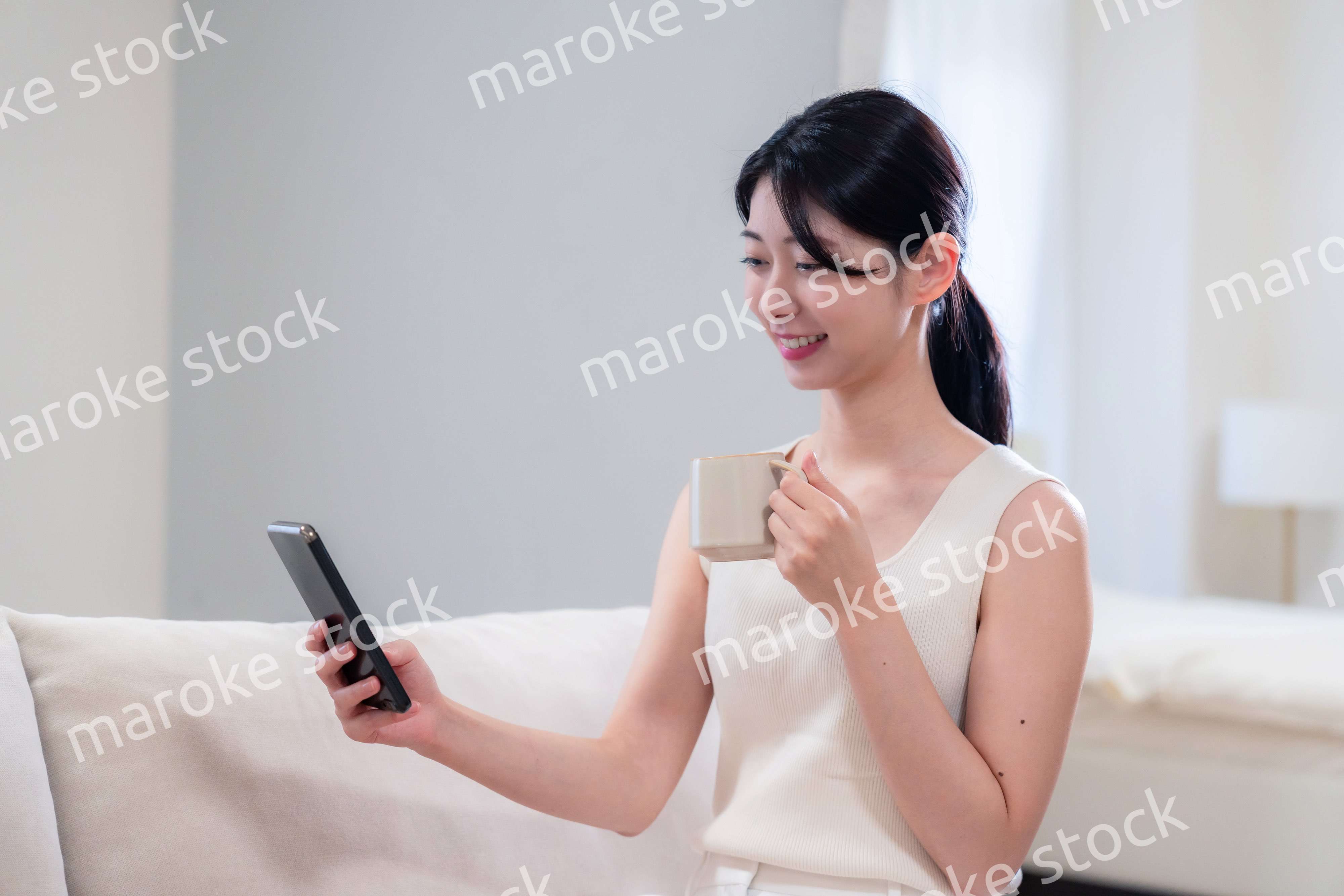 家でソファに座ってリラックスをする若い女性