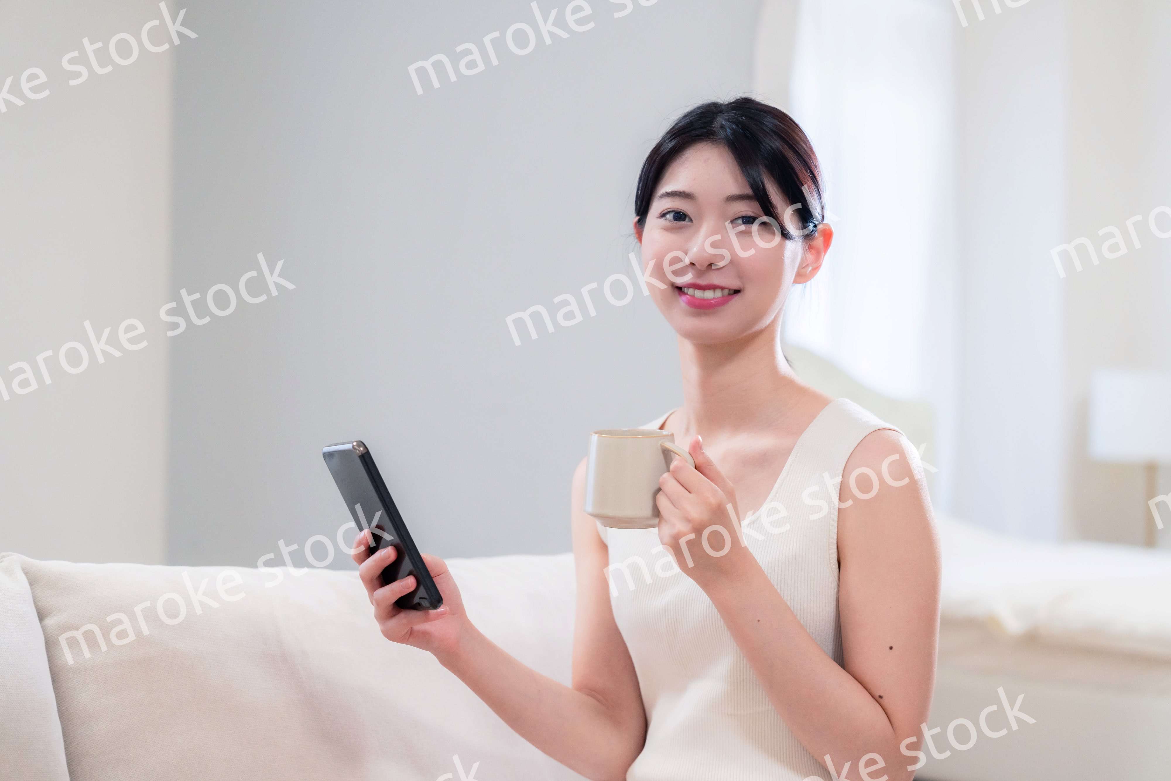 家でソファに座ってリラックスをする若い女性