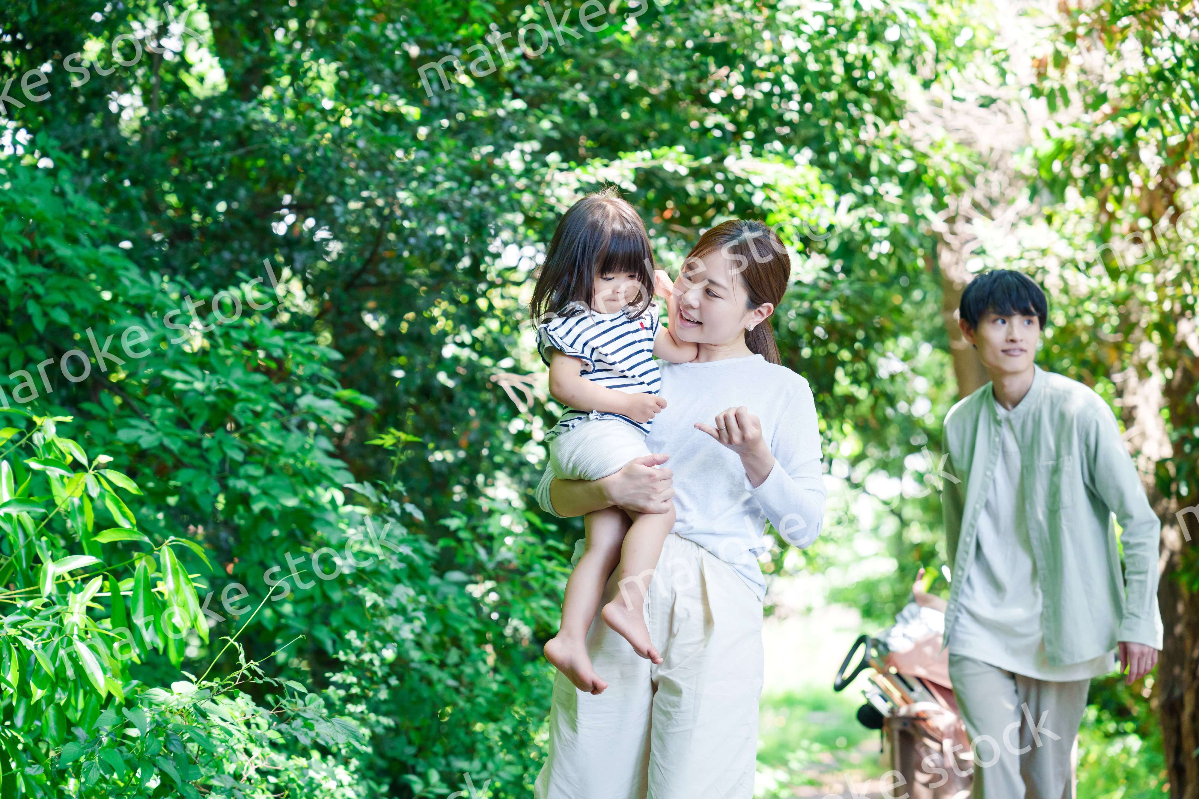 自然の中を歩いてアウトドアを楽しむ若いファミリー