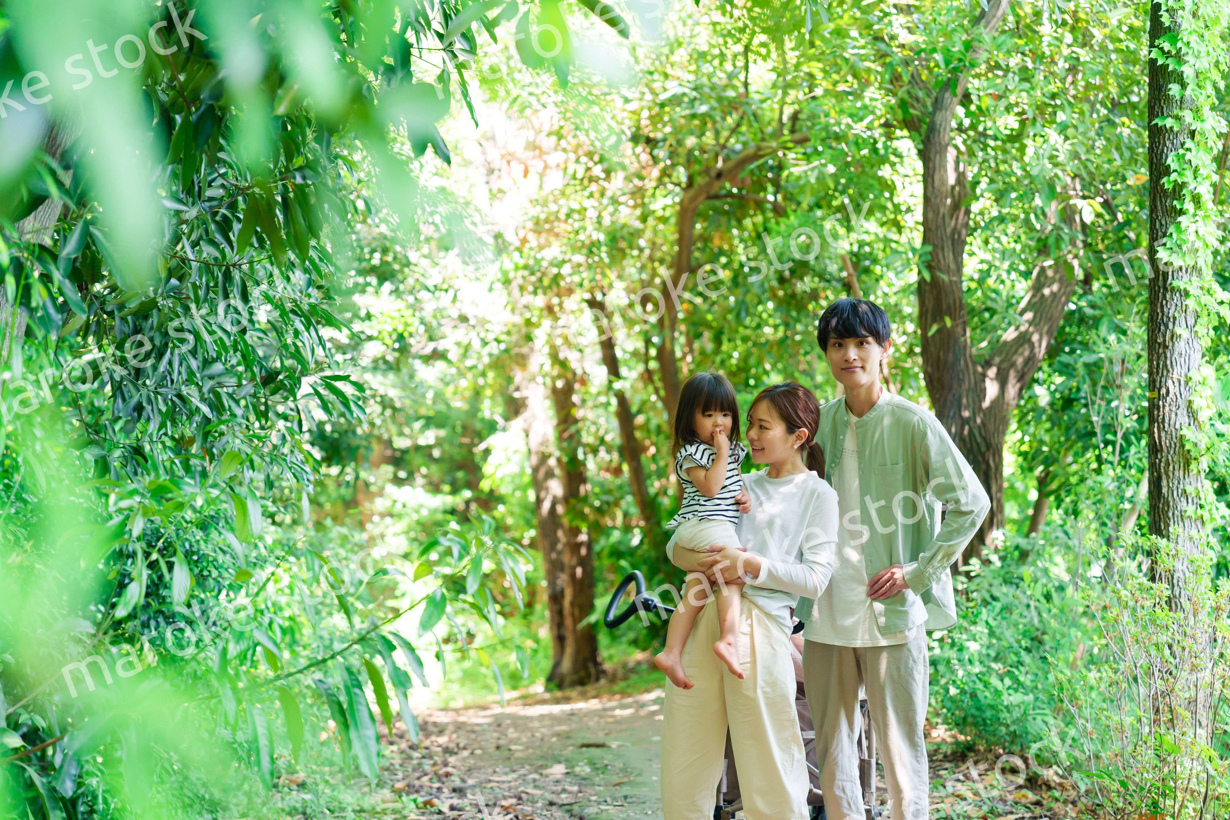 自然の中を歩いてアウトドアを楽しむ若いファミリー