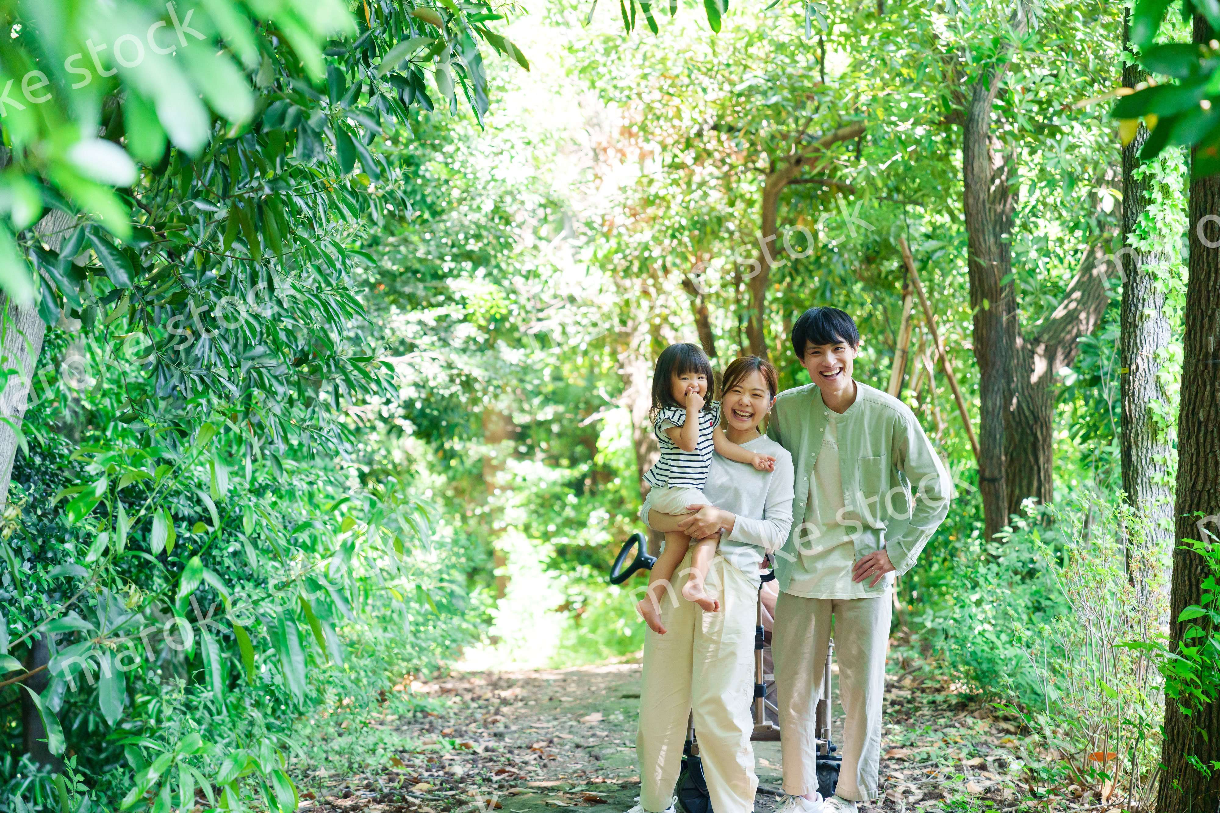 自然の中を歩いてアウトドアを楽しむ若いファミリー