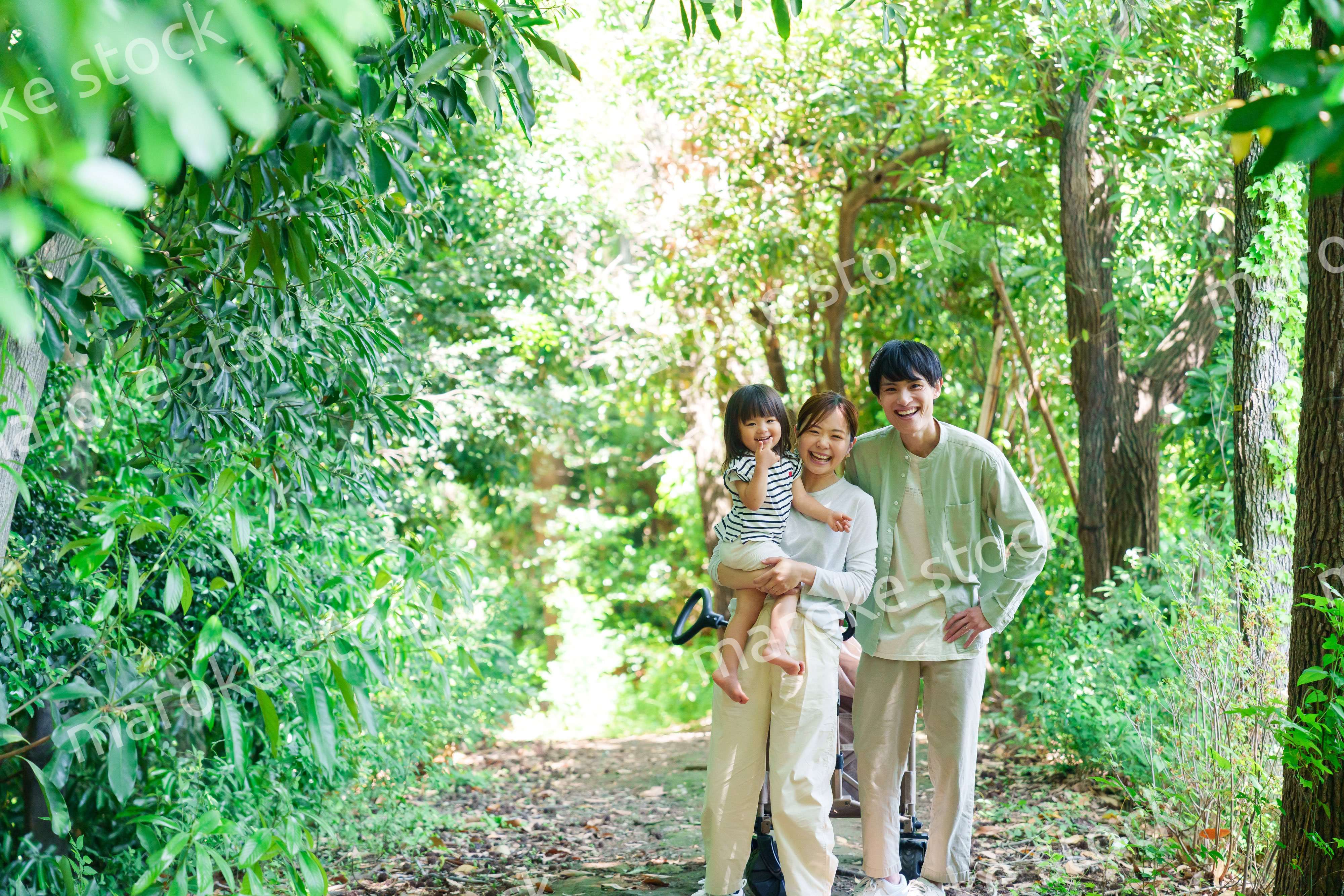 自然の中を歩いてアウトドアを楽しむ若いファミリー