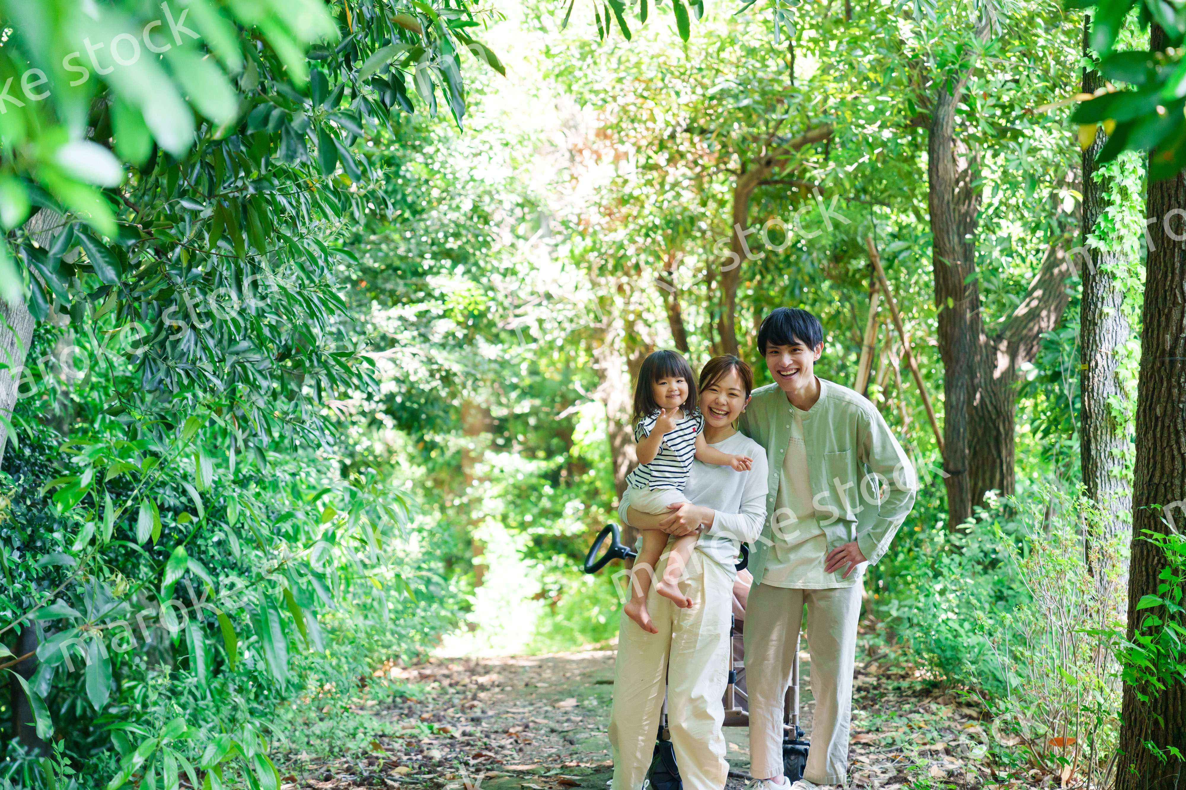 自然の中を歩いてアウトドアを楽しむ若いファミリー