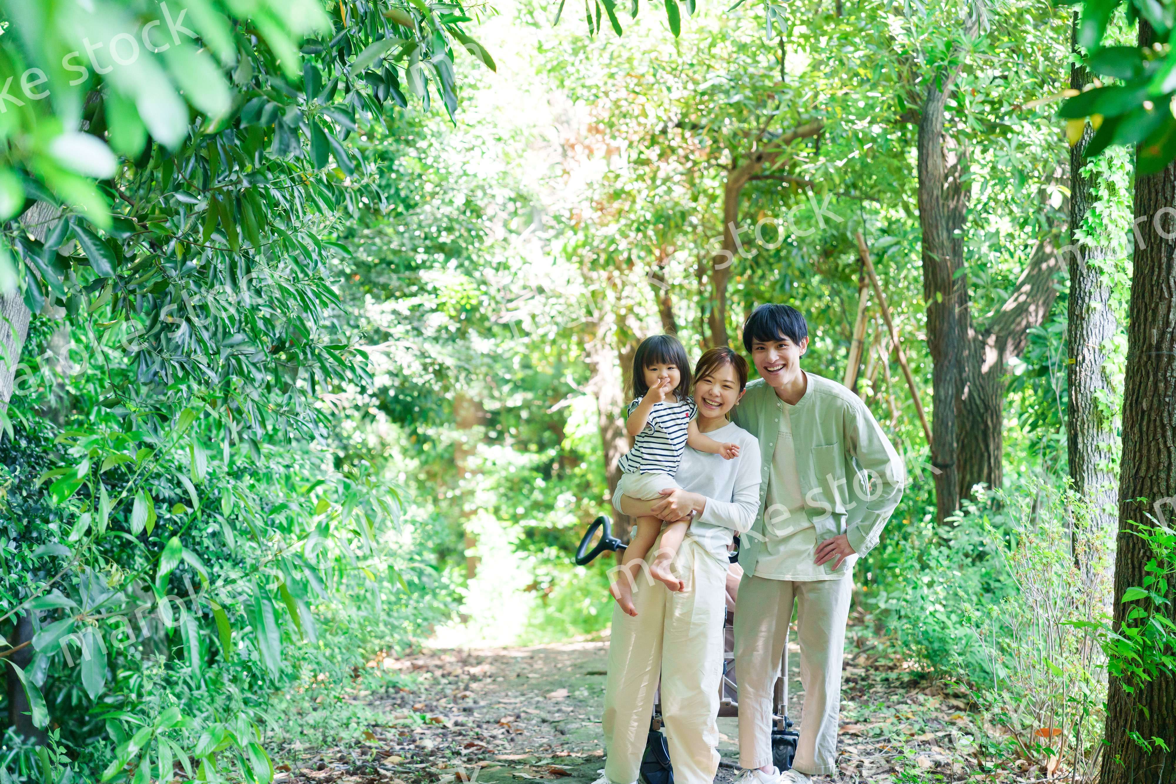 自然の中を歩いてアウトドアを楽しむ若いファミリー