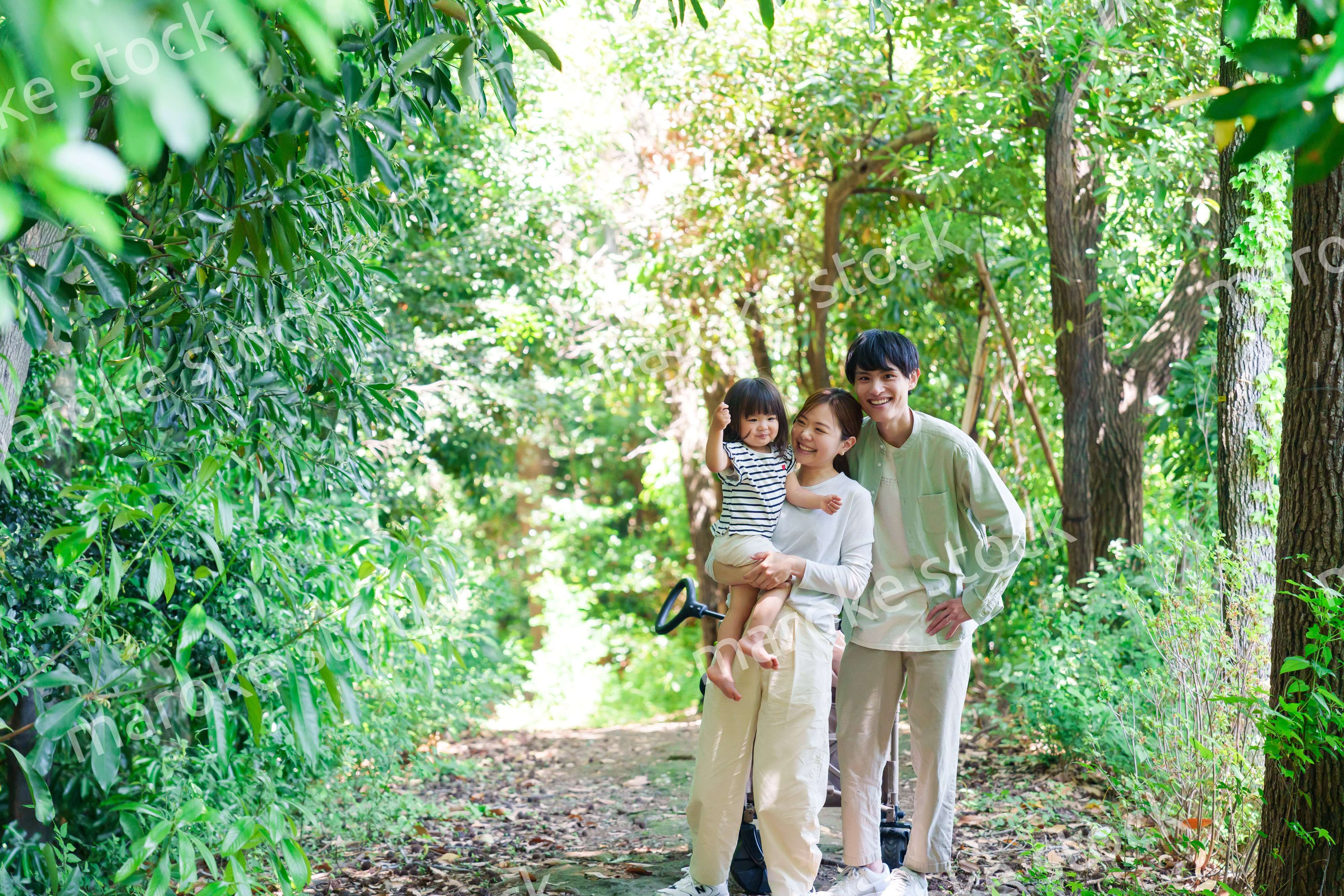 自然の中を歩いてアウトドアを楽しむ若いファミリー