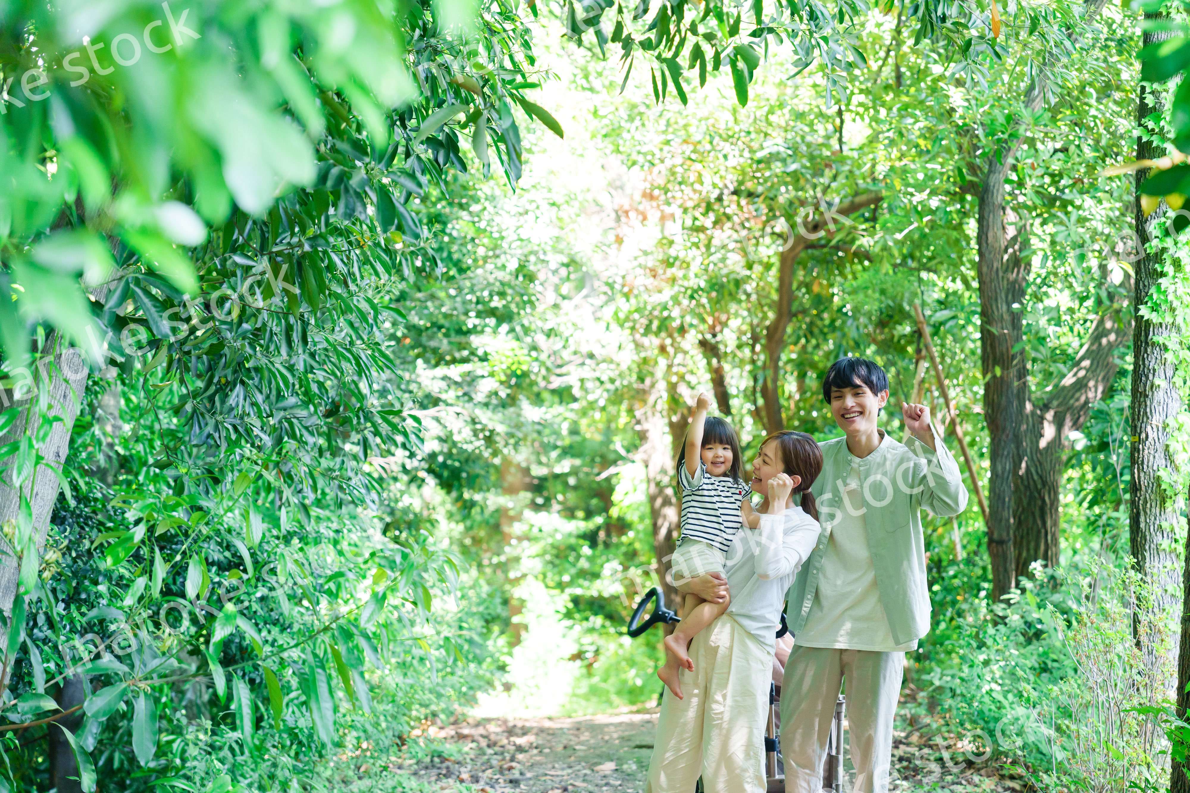 自然の中を歩いてアウトドアを楽しむ若いファミリー