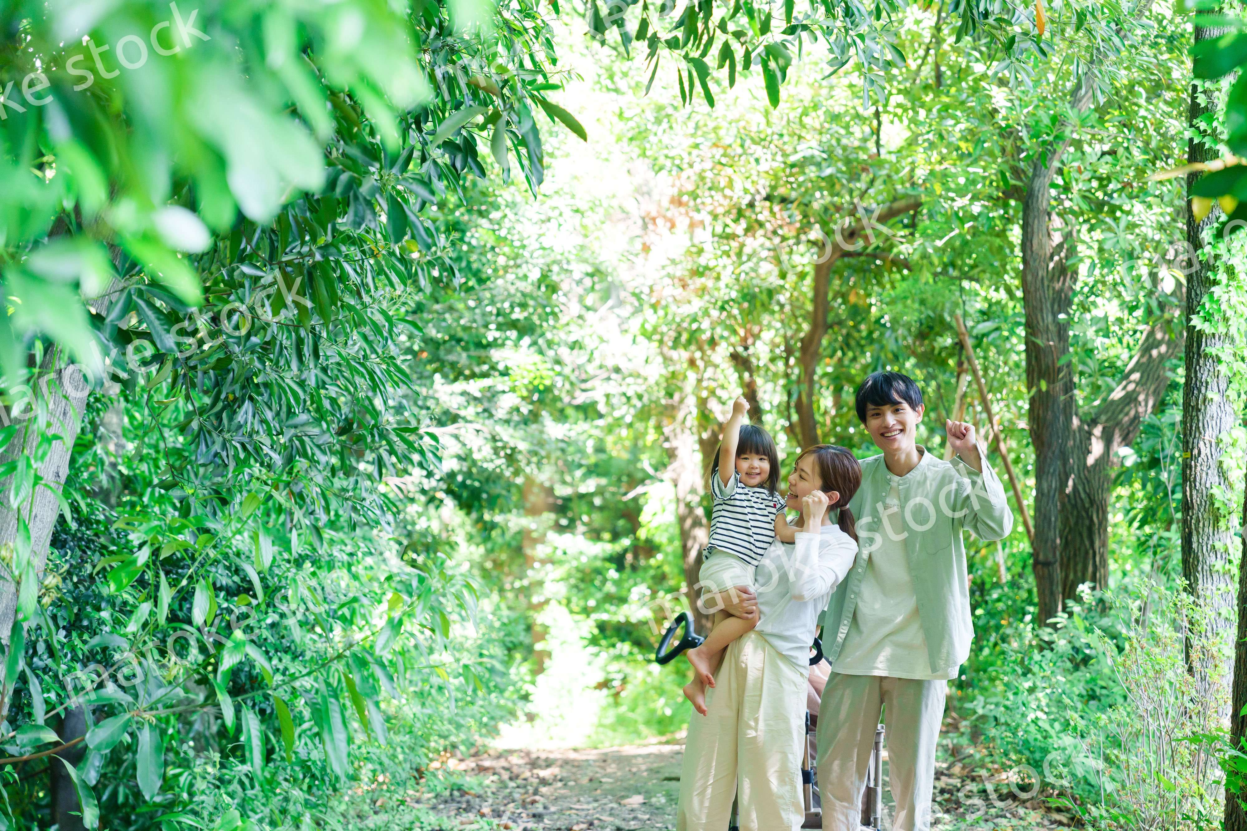 自然の中を歩いてアウトドアを楽しむ若いファミリー