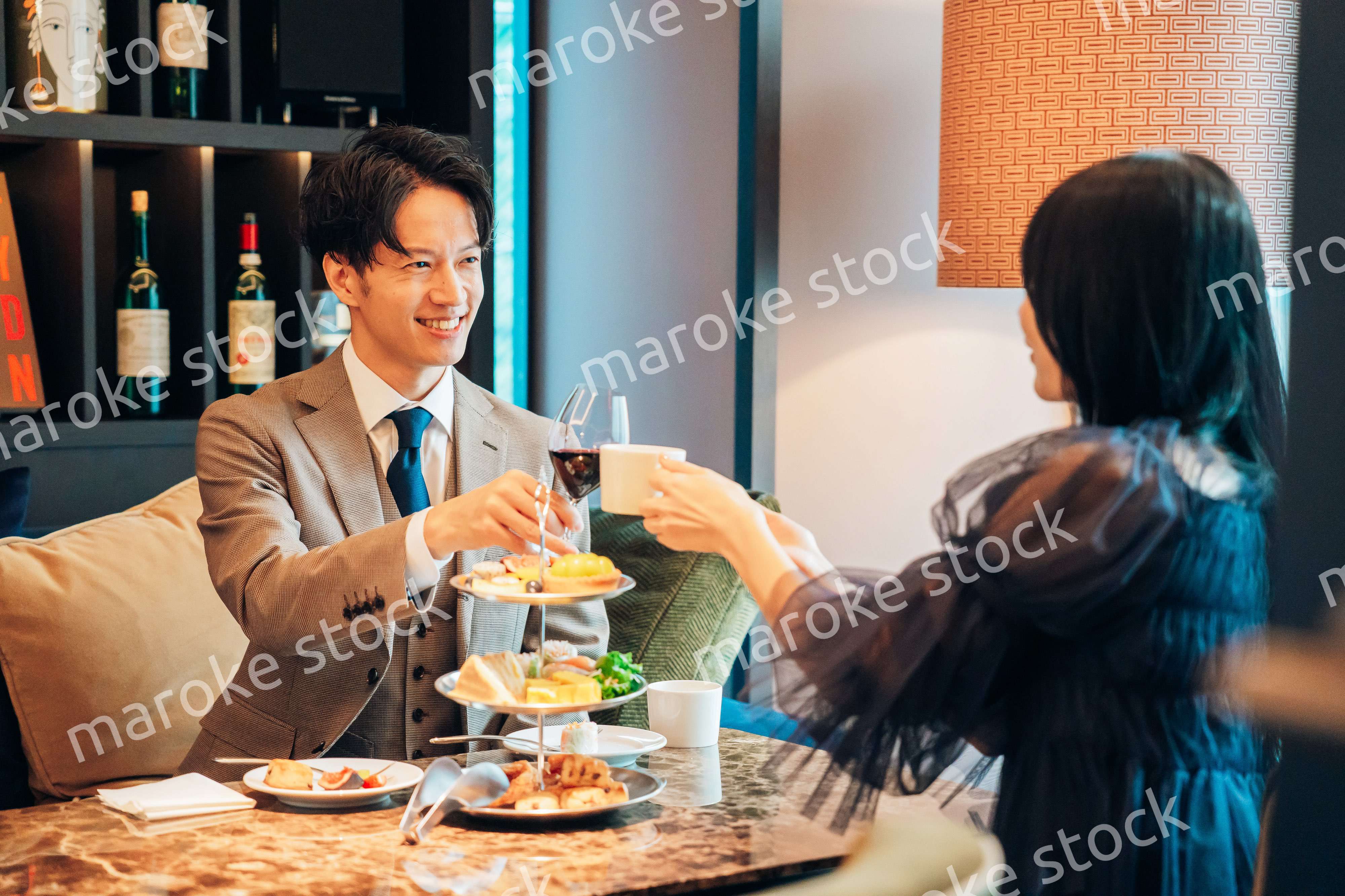 若い女性とアフタヌーンティーを楽しむ男性