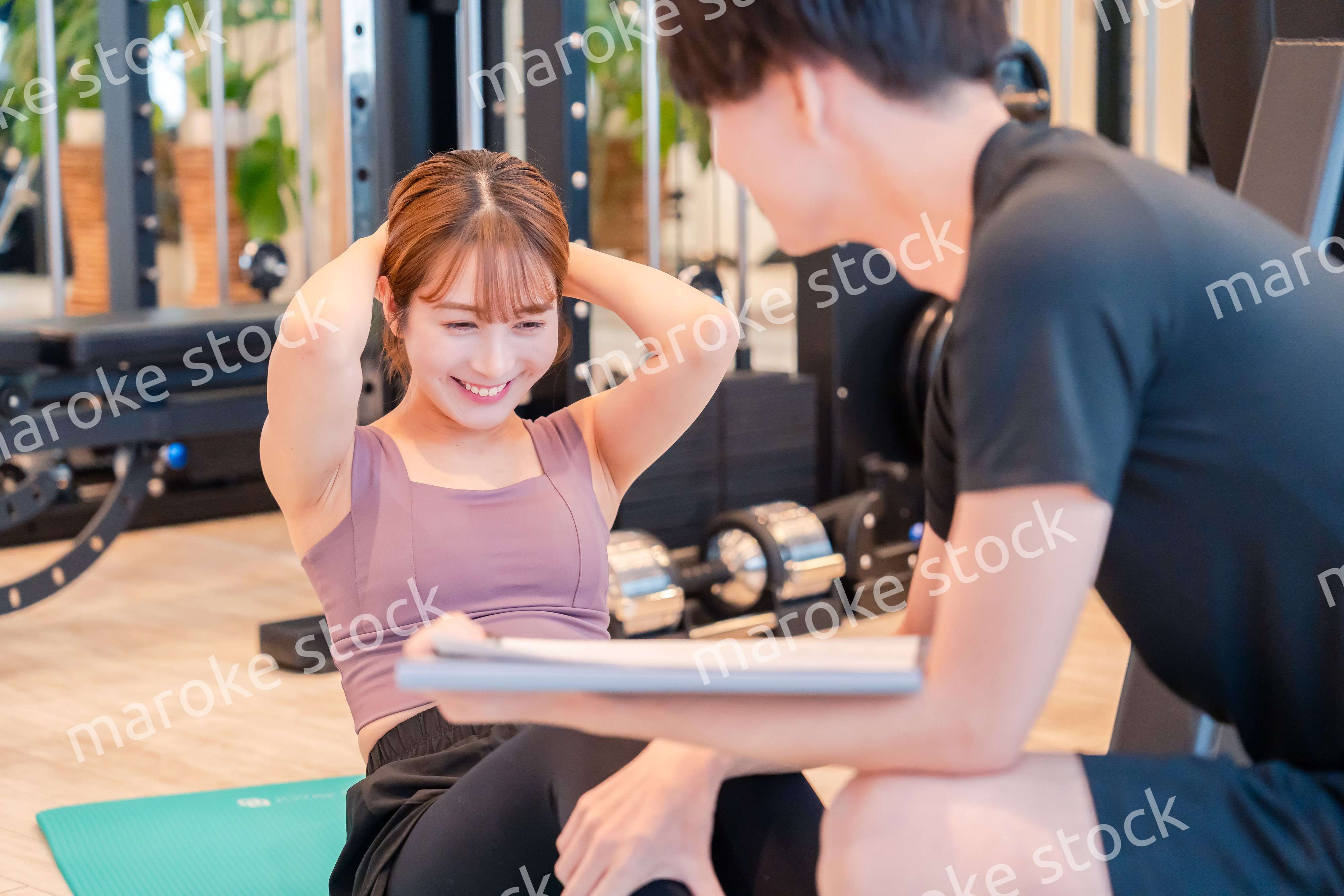 パーソナルジムに通う女性とトレーナー