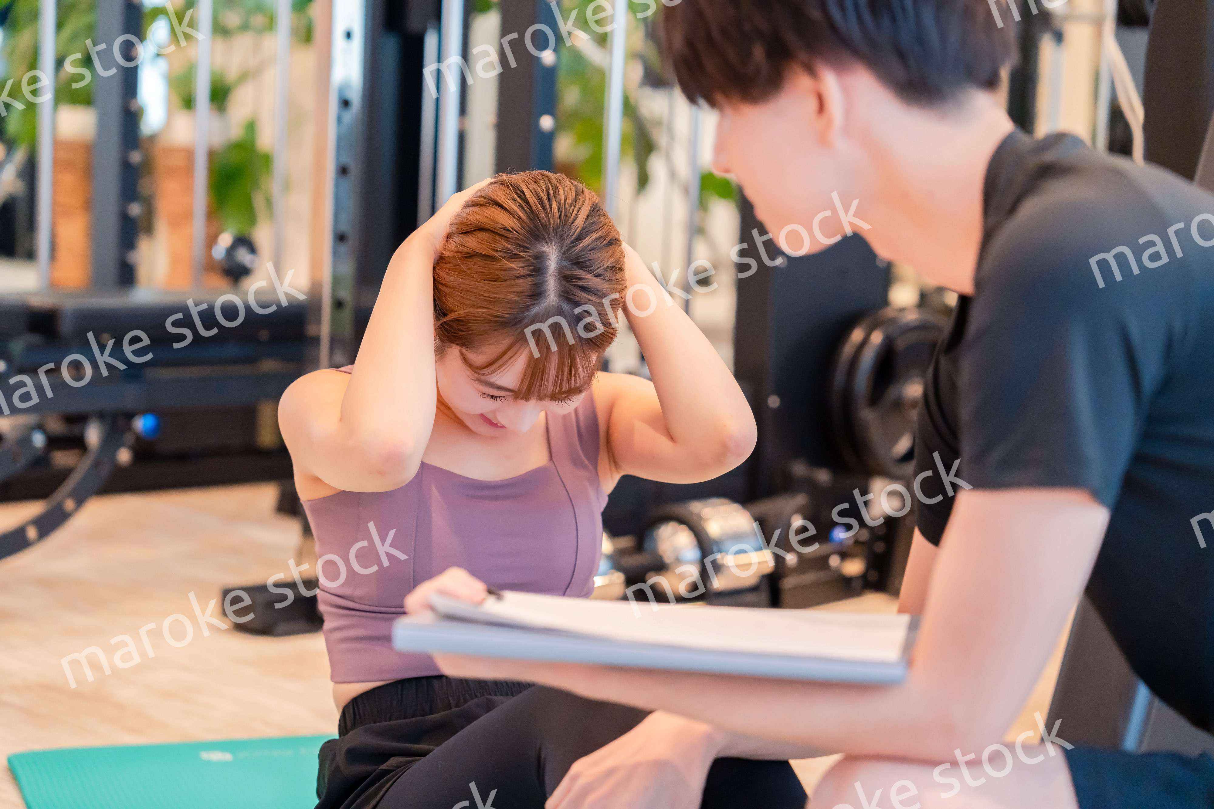 パーソナルジムに通う女性とトレーナー