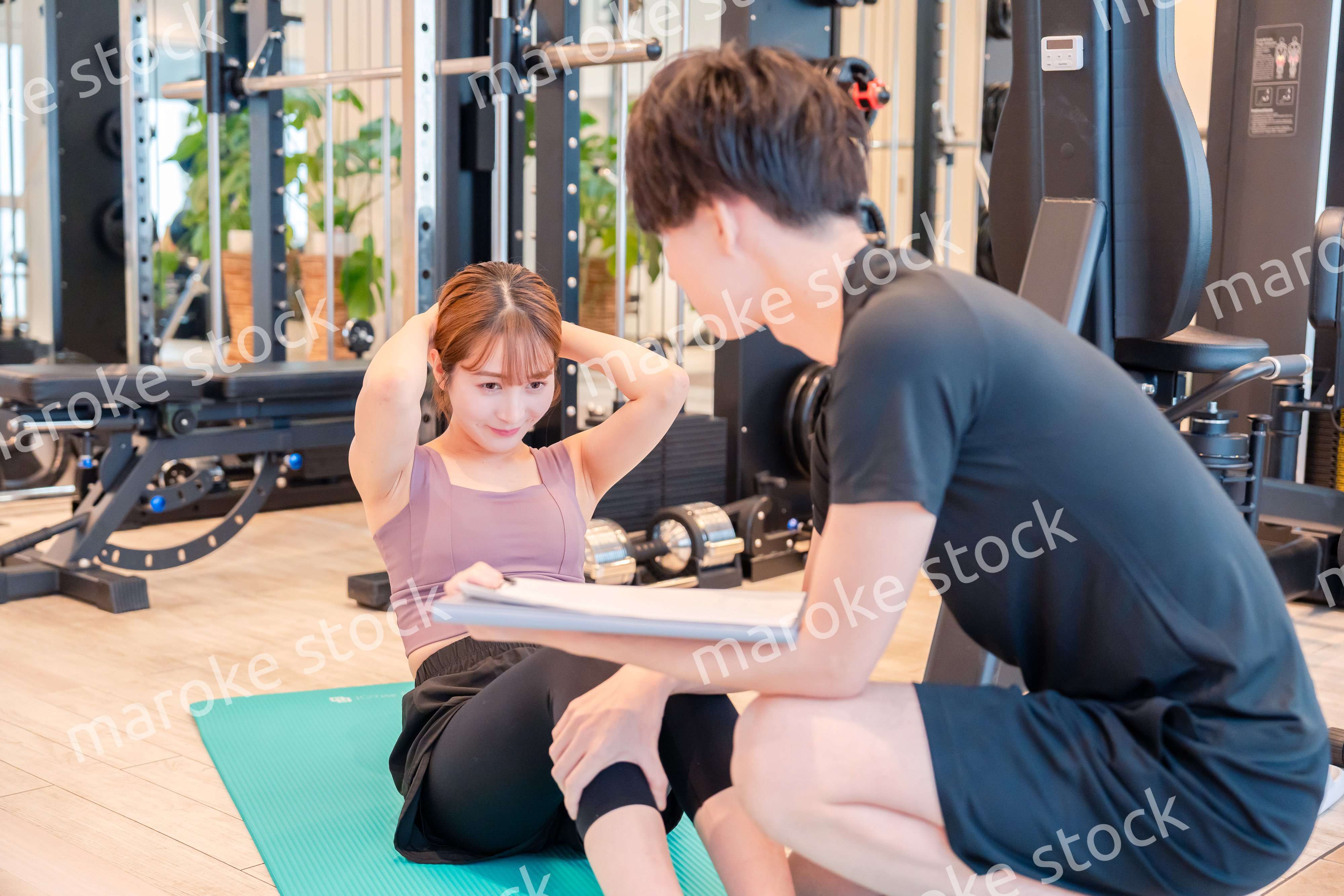 パーソナルジムに通う女性とトレーナー
