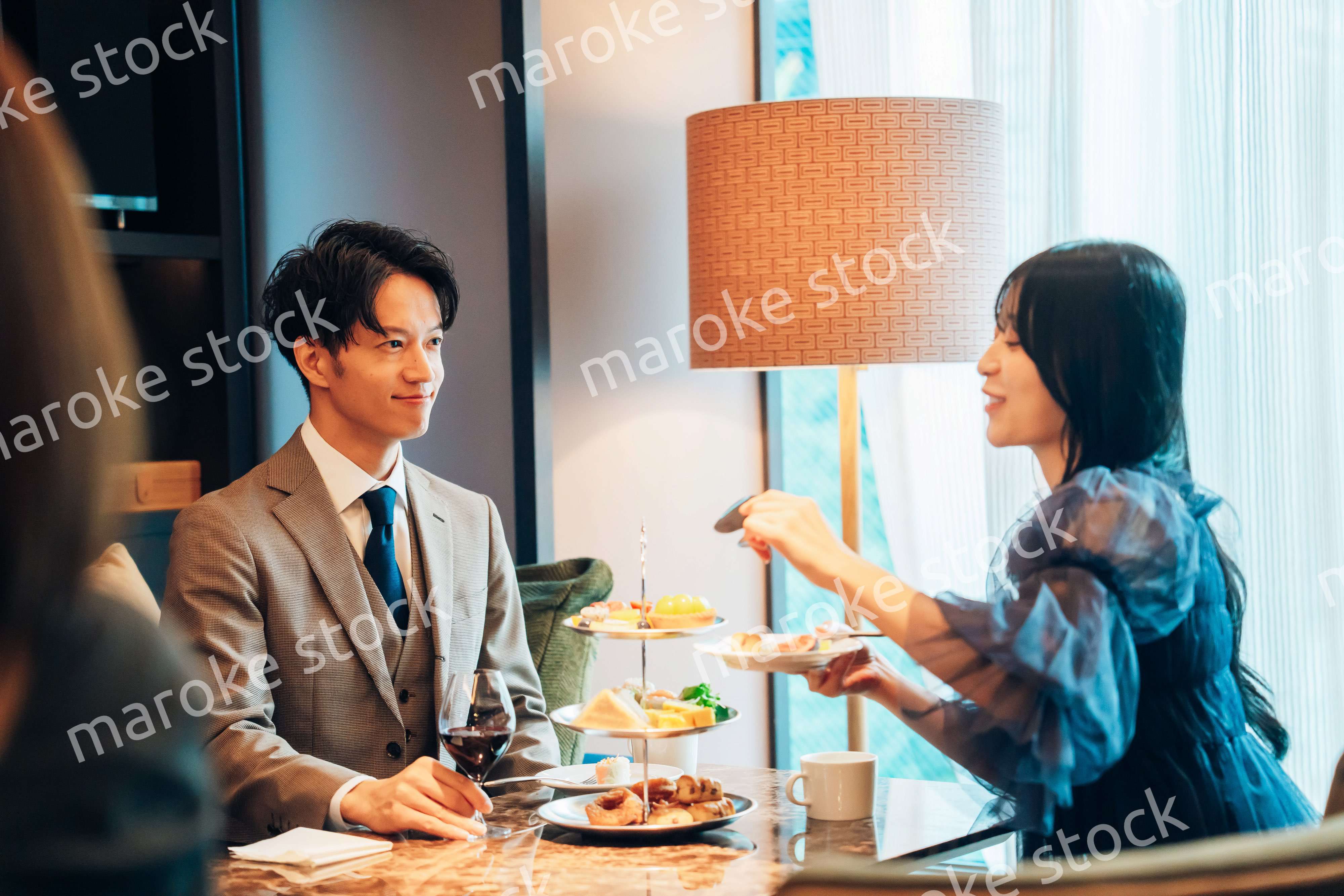 若い女性とアフタヌーンティーを楽しむ男性