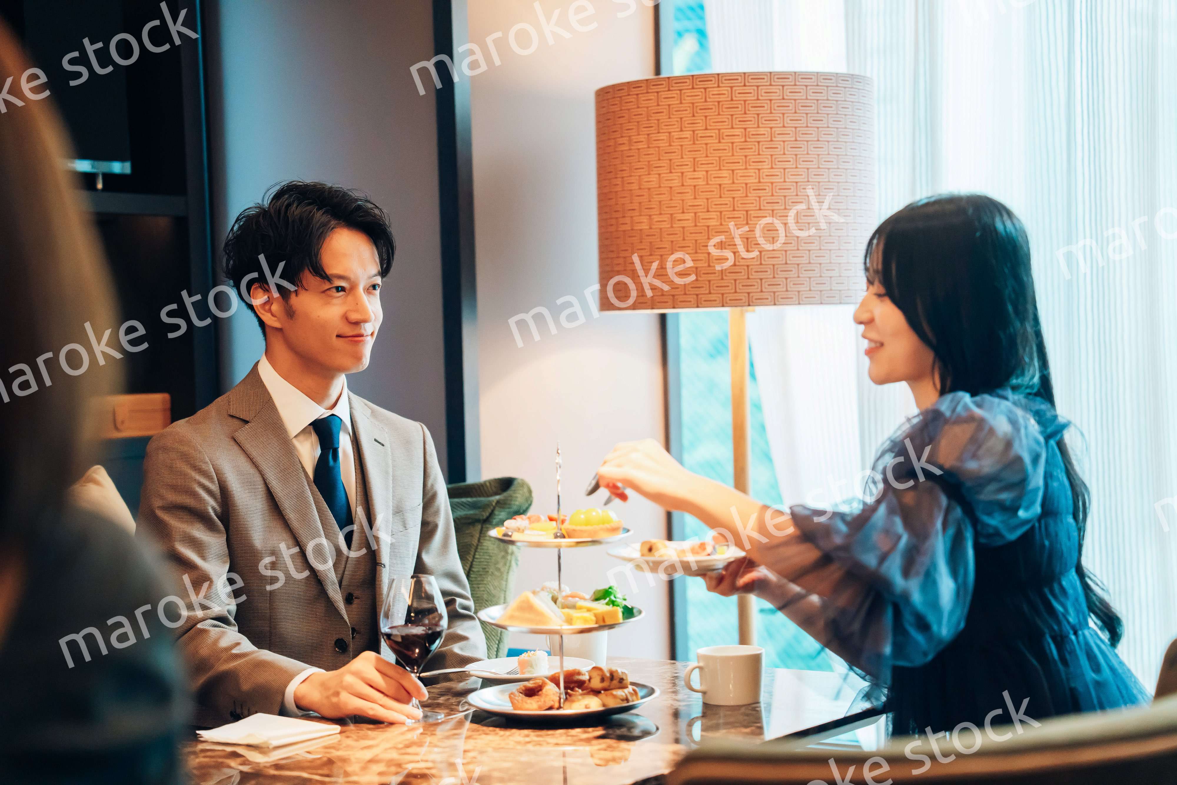 若い女性とアフタヌーンティーを楽しむ男性