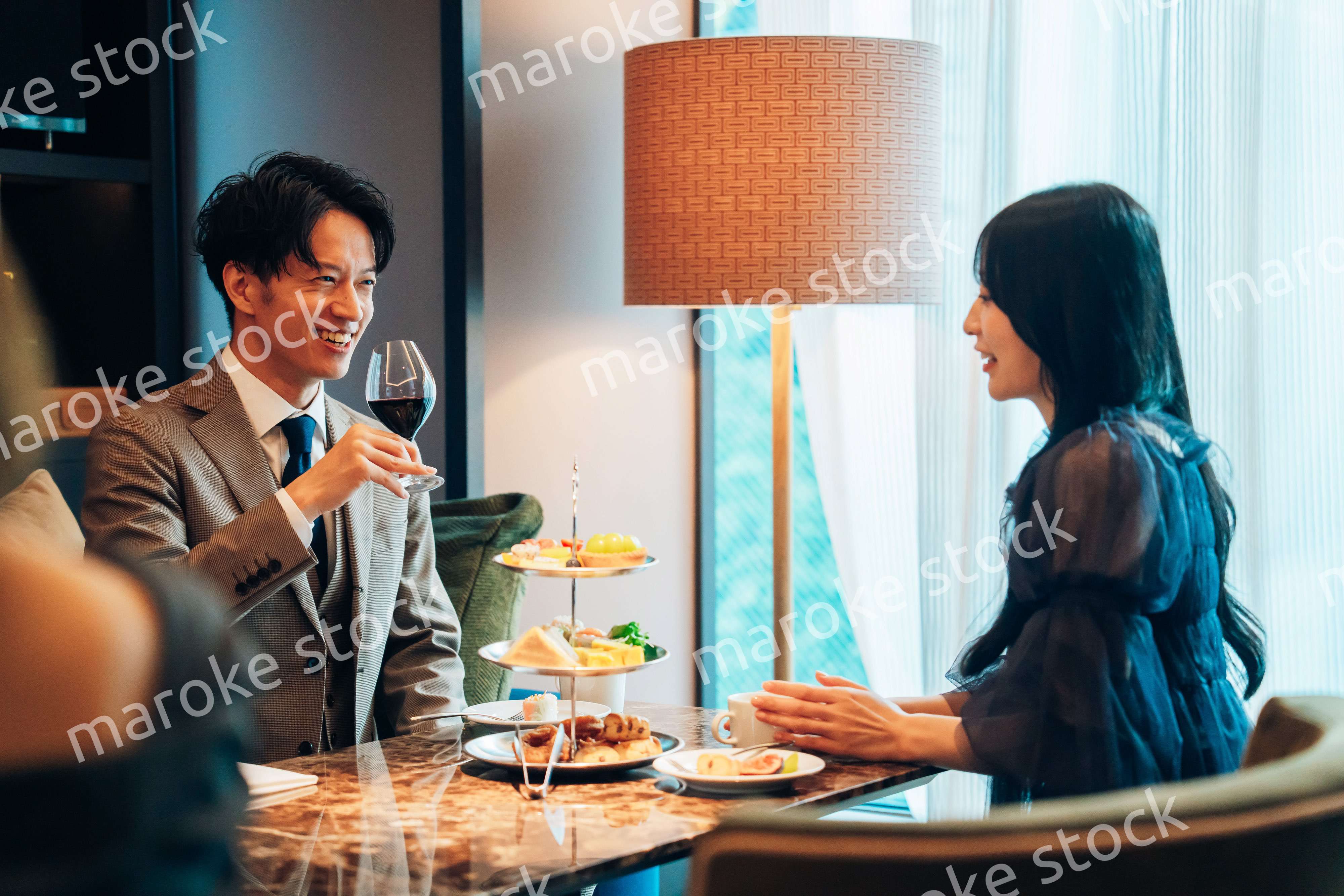 若い女性とアフタヌーンティーを楽しむ男性