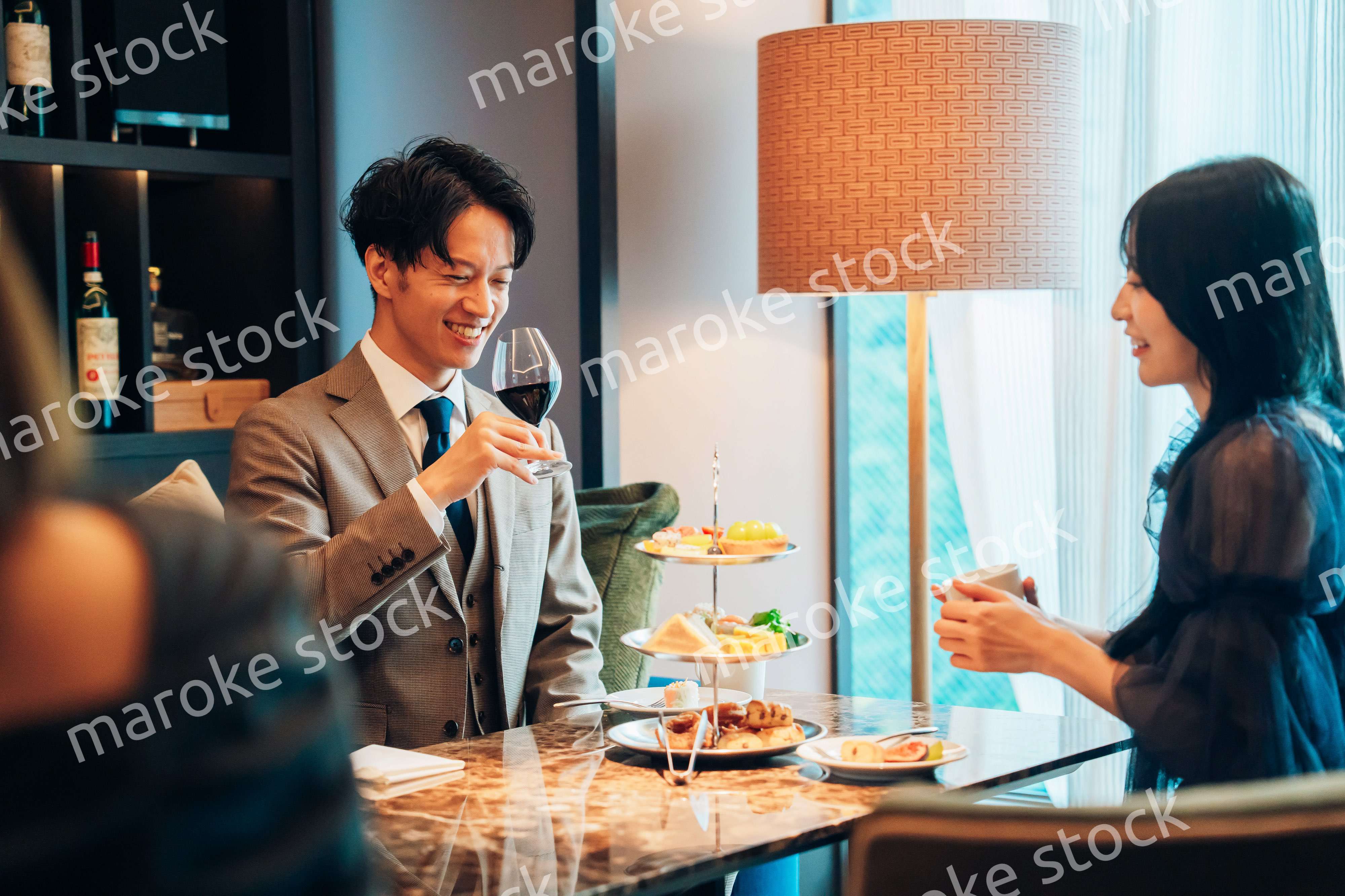 若い女性とアフタヌーンティーを楽しむ男性