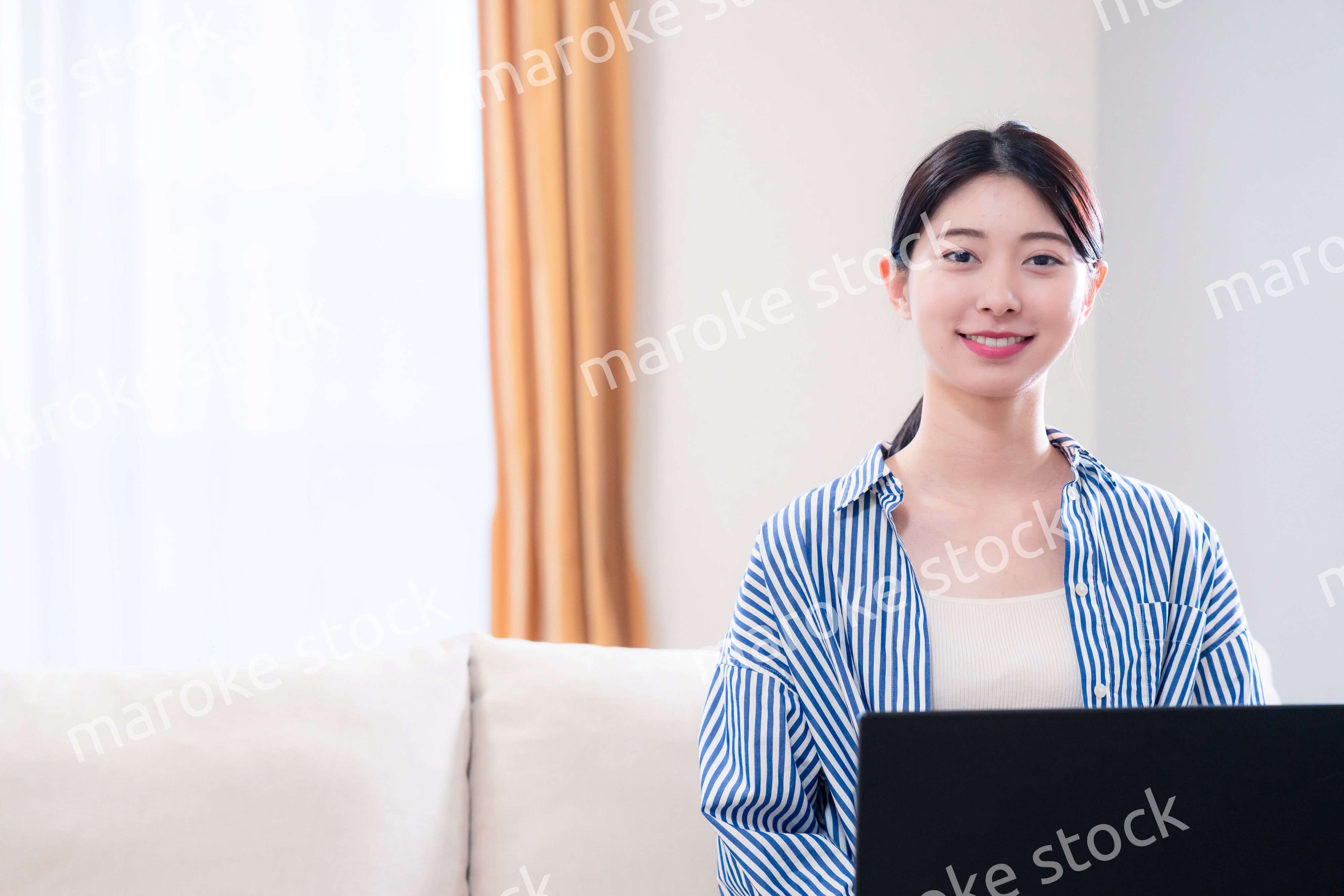 家でリラックスをしてパソコンを使う若い女性